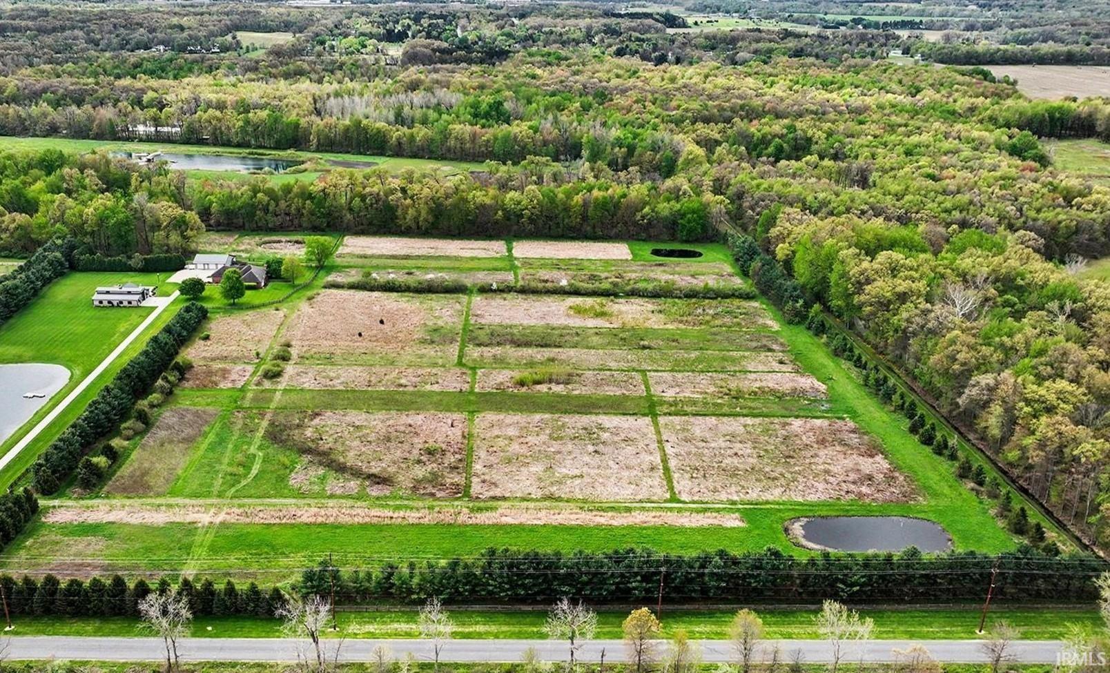 Expansive property featuring structured fields, two ponds, and mature tree lines