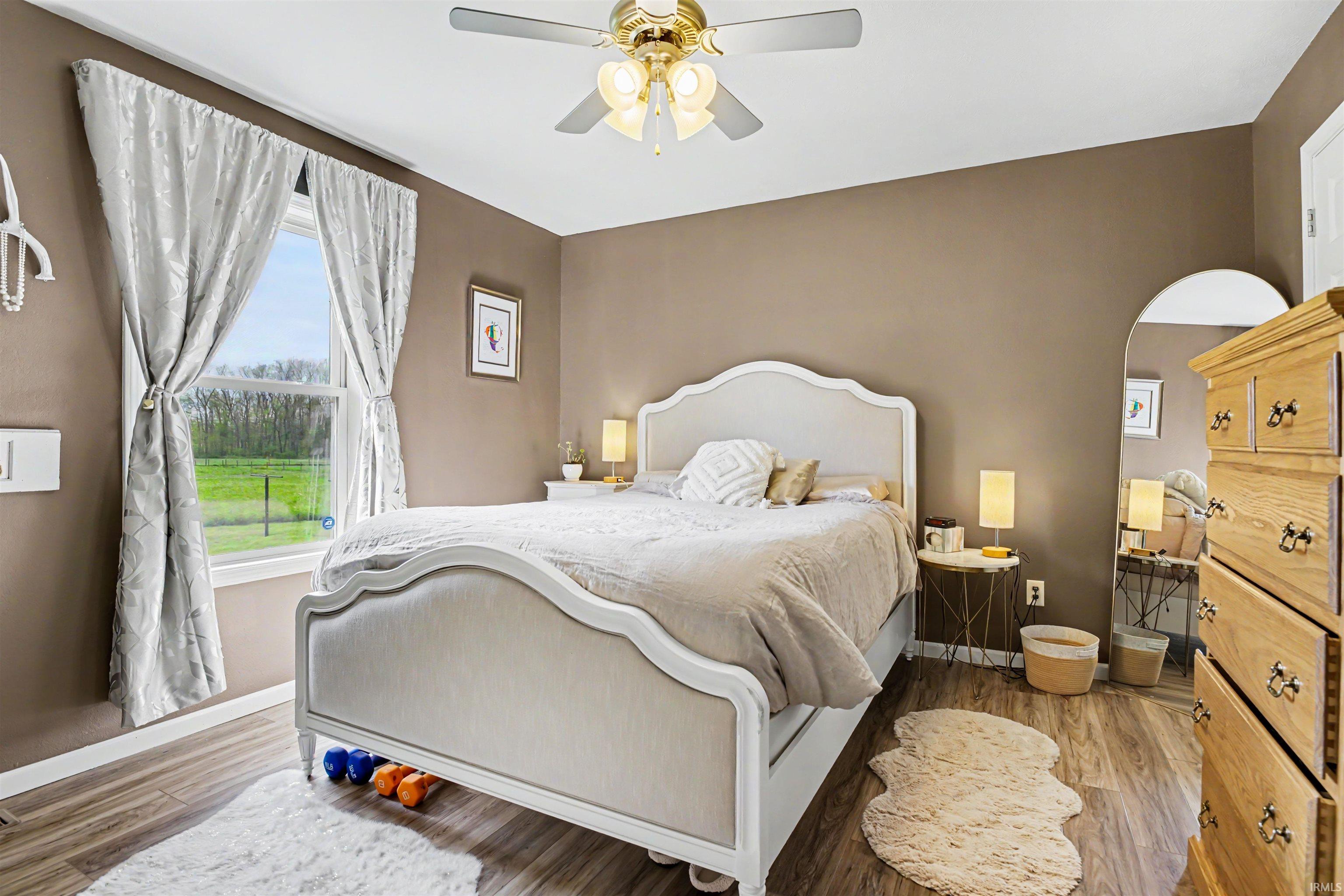 Primary Bedroom featuring wood-finish flooring an en suite bathroom