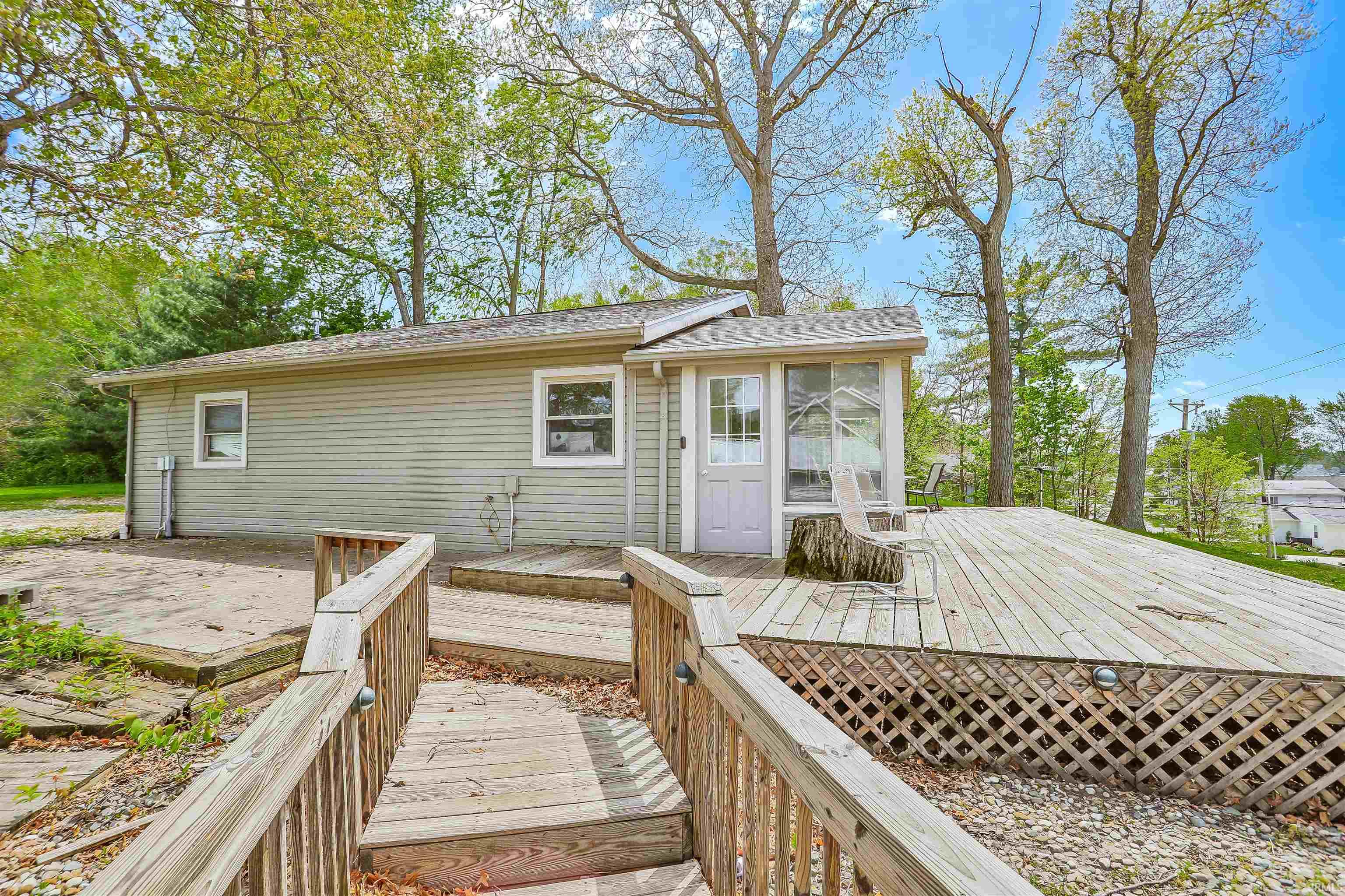 Expansive rear deck with lattice skirting and a built-in ramp, offering direct access to the home's exterior