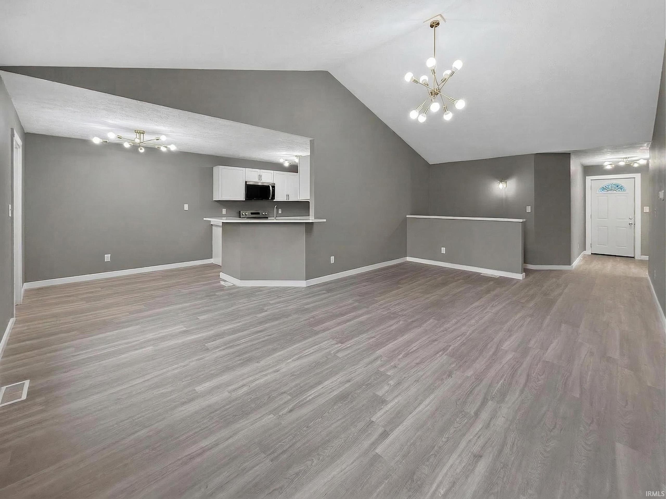 Expansive living area featuring vaulted ceilings and light wood-finish flooring