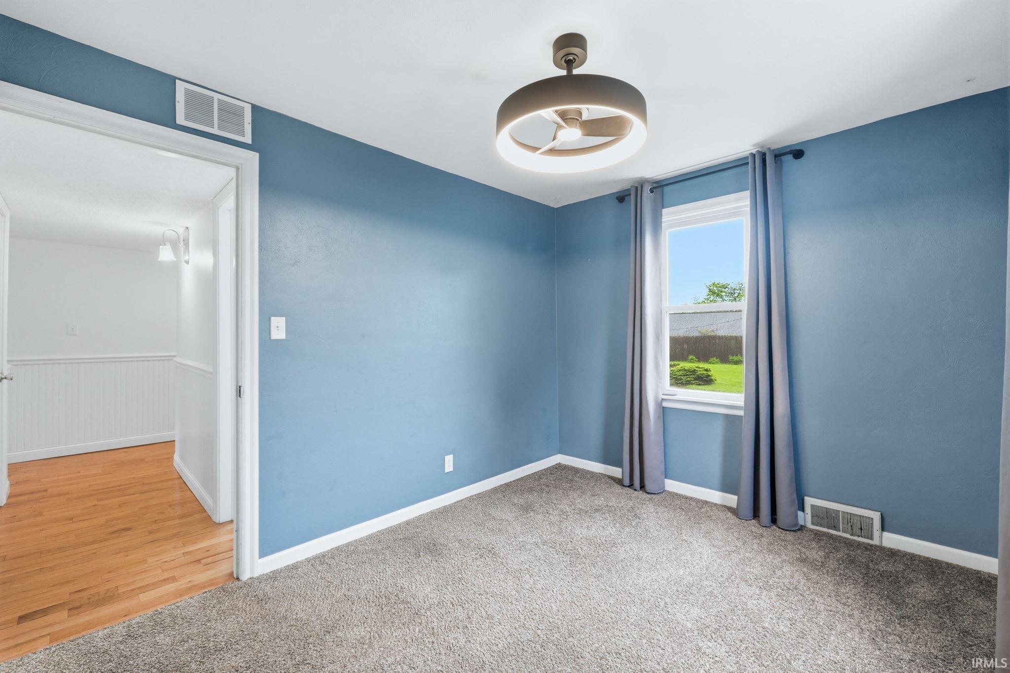 Room featuring blue walls and light gray carpeting