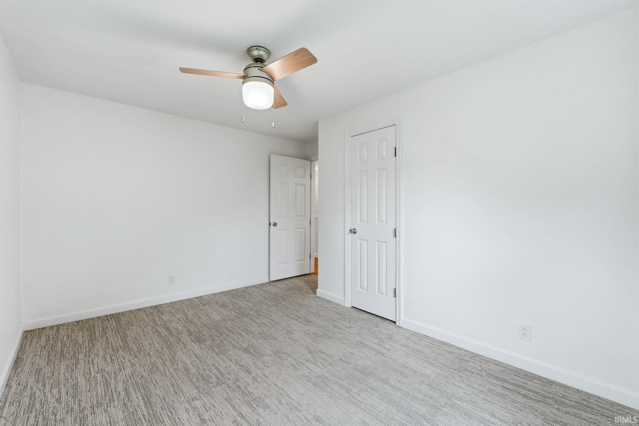 Room featuring light gray patterned carpeting and white painted walls