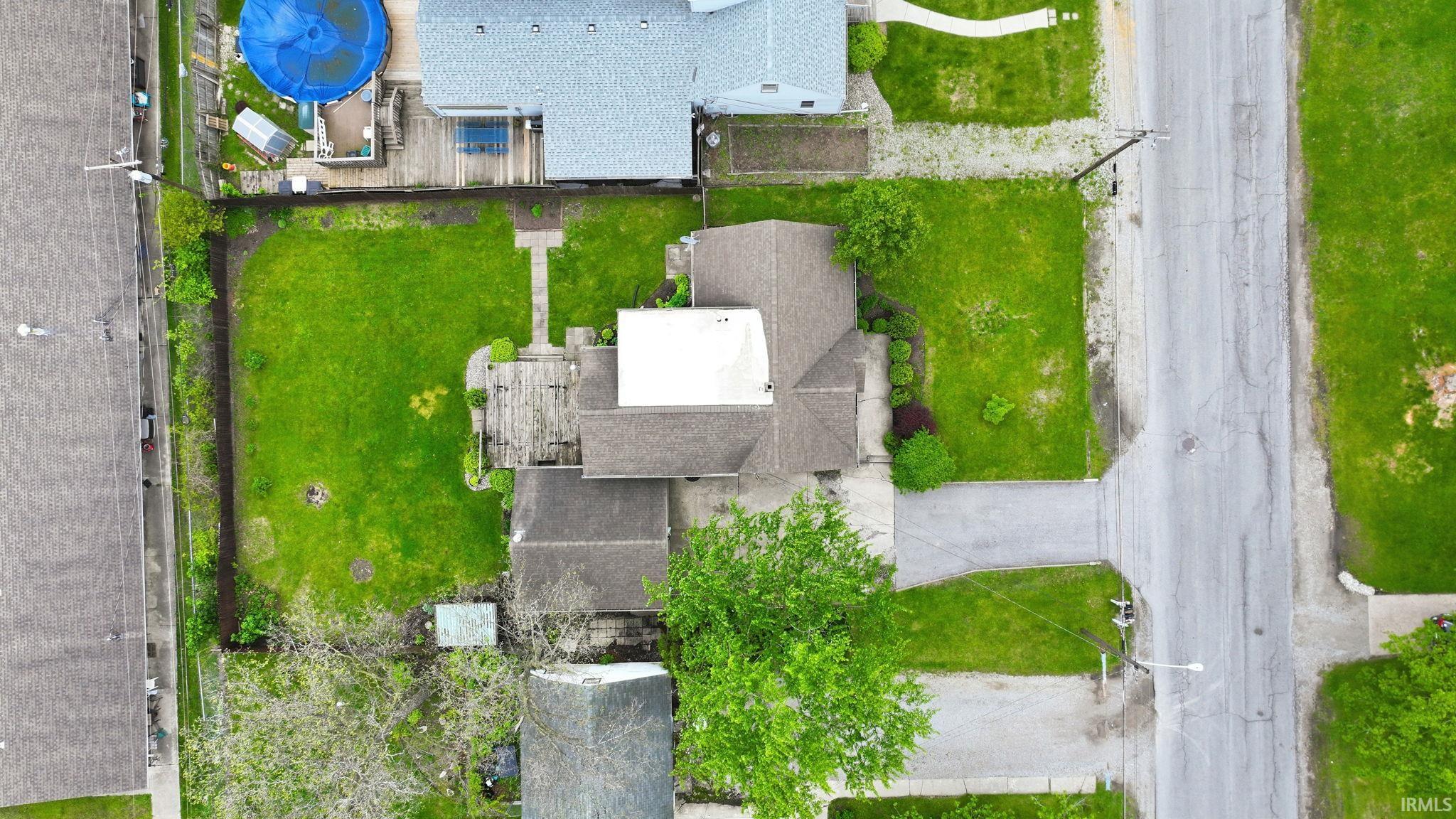 Expansive green spaces define this property, featuring a large backyard with a wooden deck and a front yard with mature landscaping