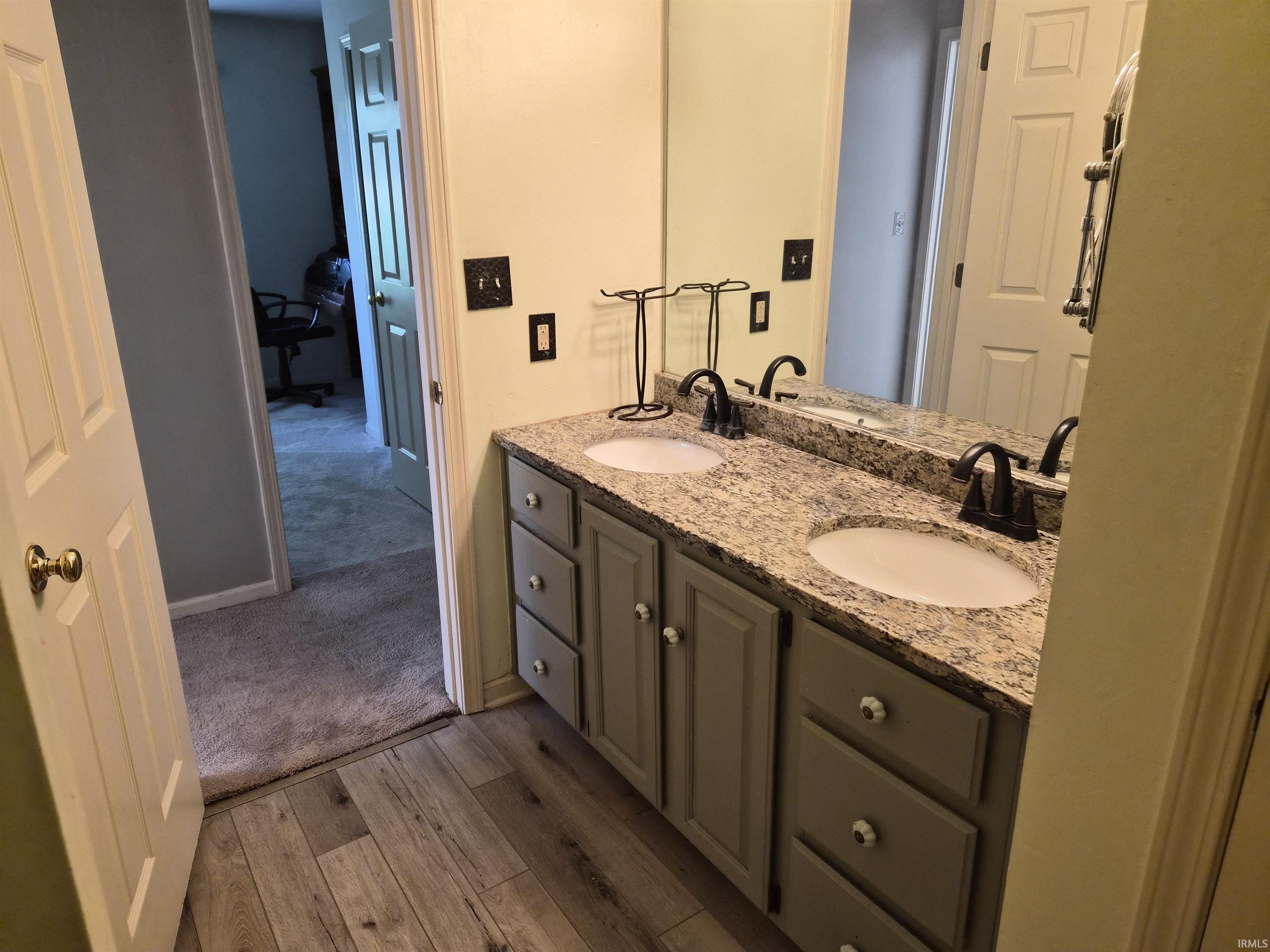 Dual vanity with light-toned granite countertop, two undermount sinks, and dark bronze faucets