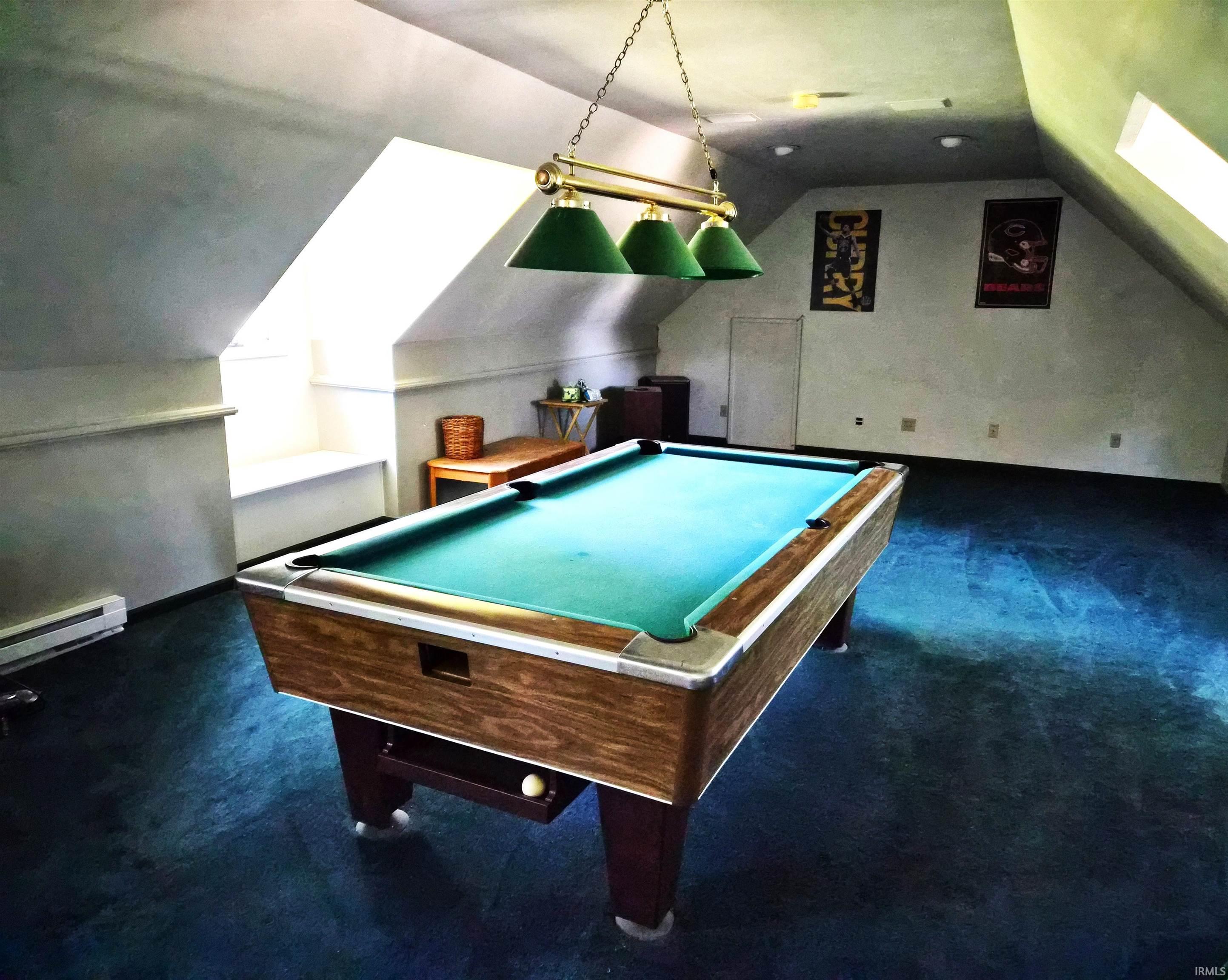 Spacious bonus room featuring a full-size billiard table under a brass-finish light fixture with green shades