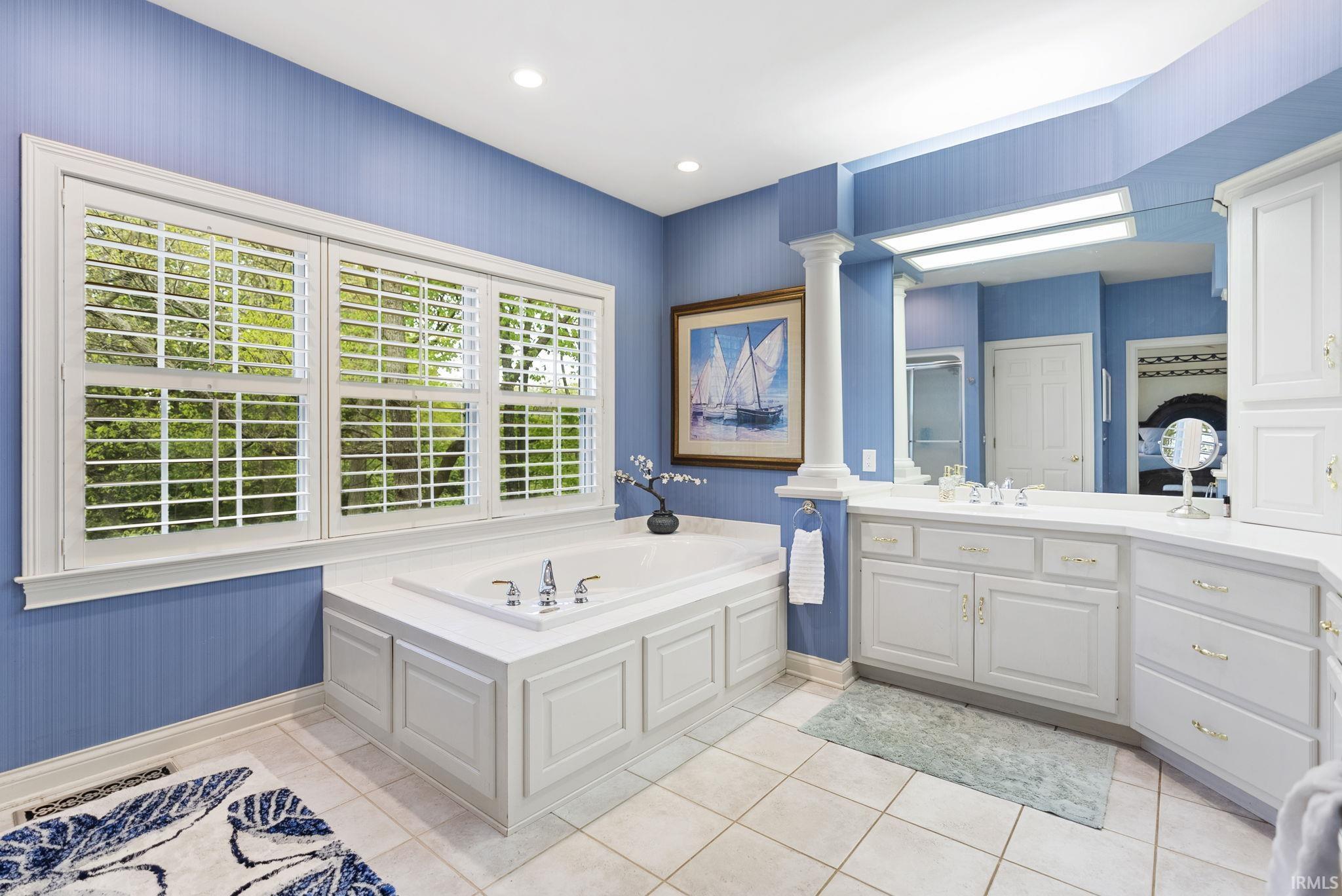 Soaking tub with white paneling and a deck-mounted faucet