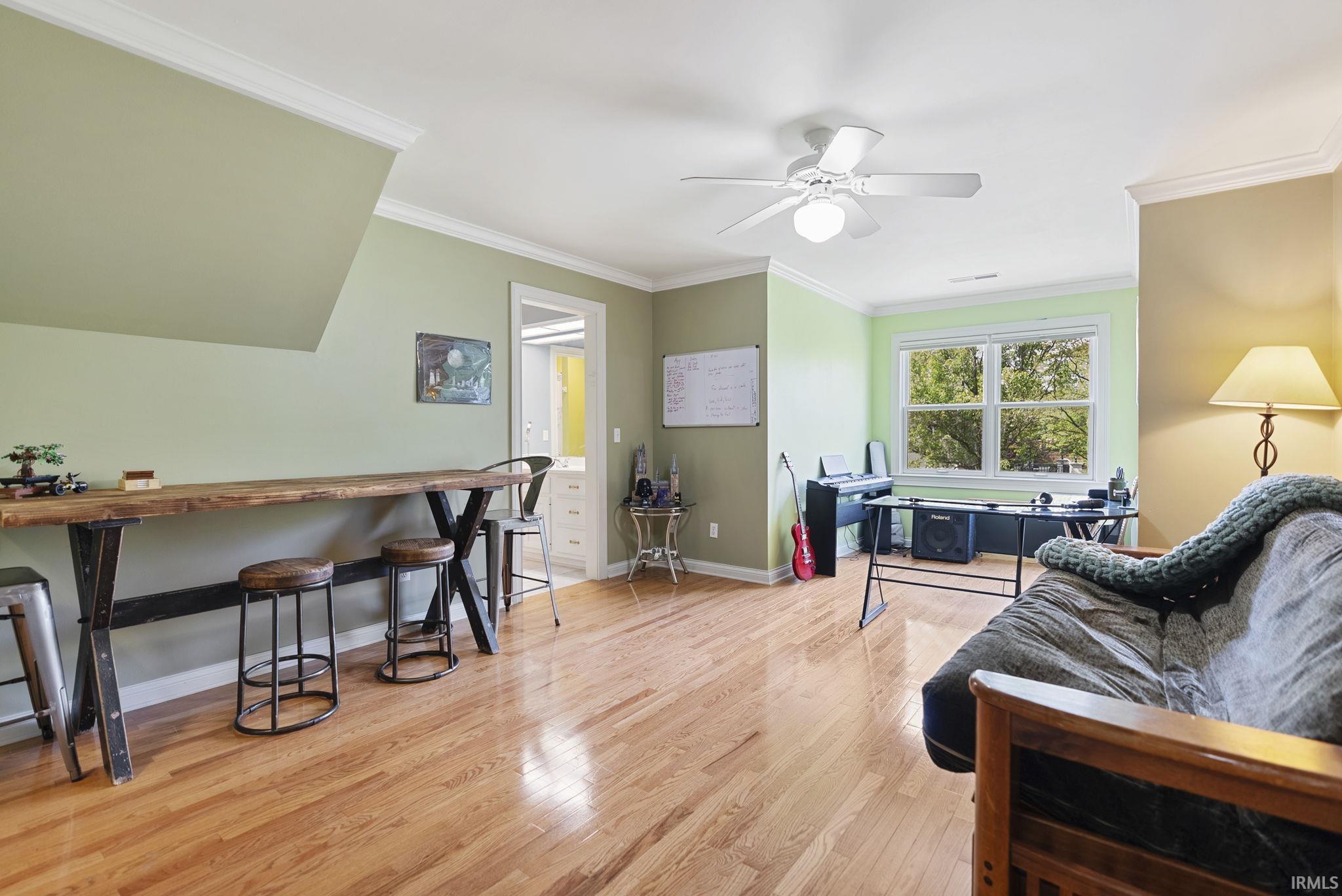 Hardwood flooring throughout the room, featuring a built-in wooden bar top with metal supports