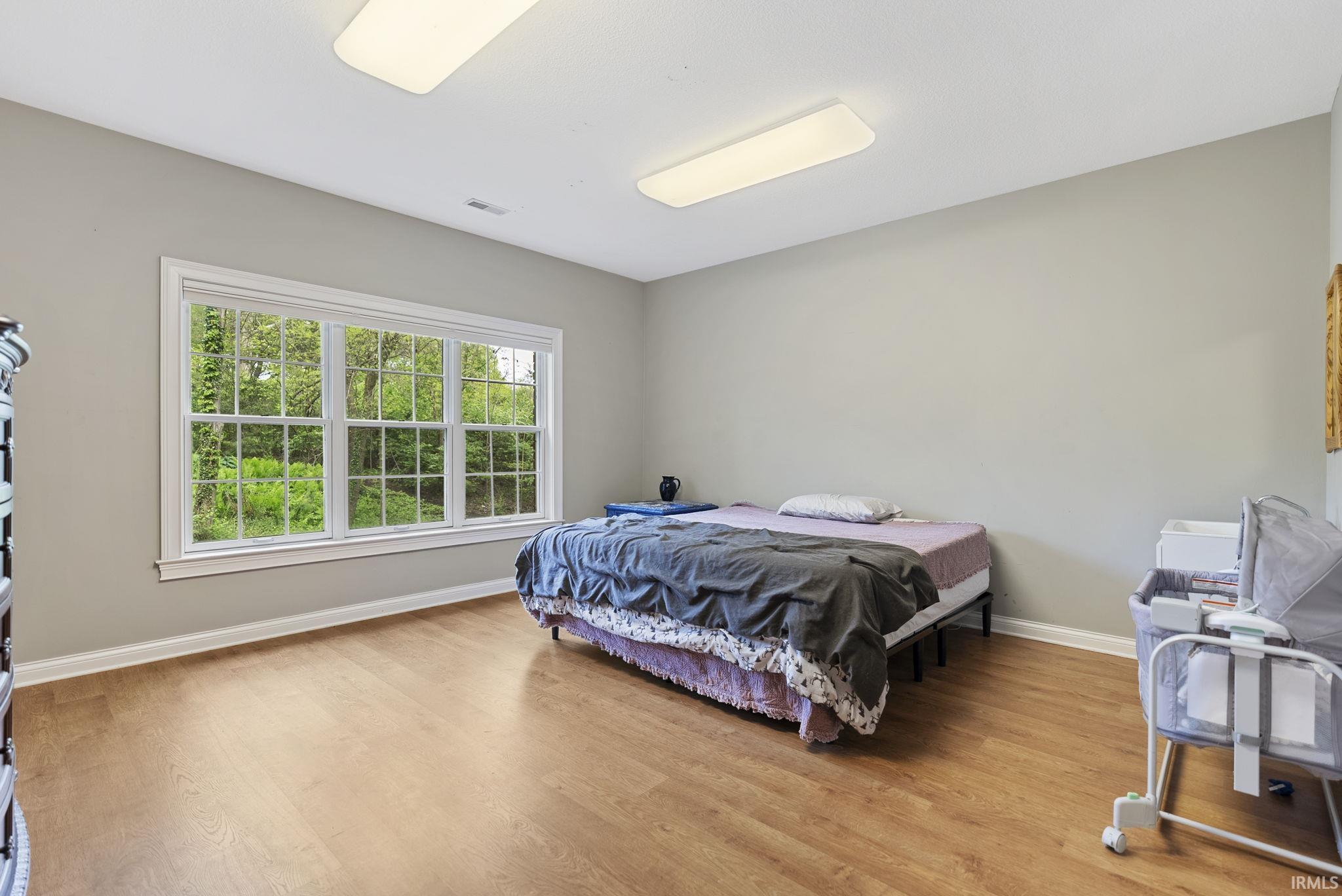 Spacious room with light-toned wood-finish flooring and neutral wall paint