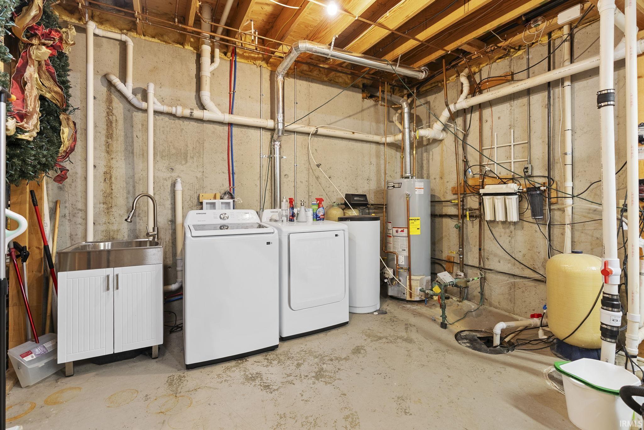 Basement utility area featuring exposed concrete walls and ceiling joists
