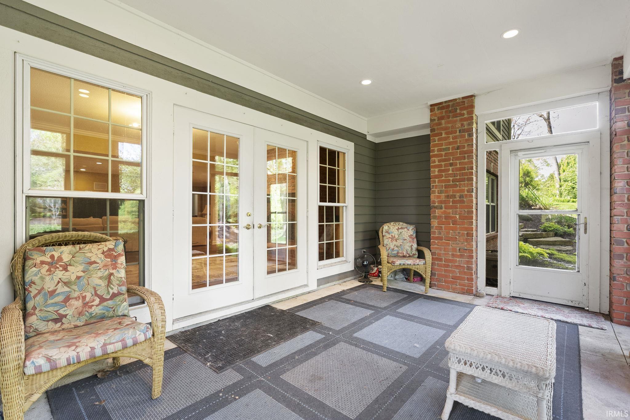 Covered patio featuring a brick column, recessed lighting, and a screen door
