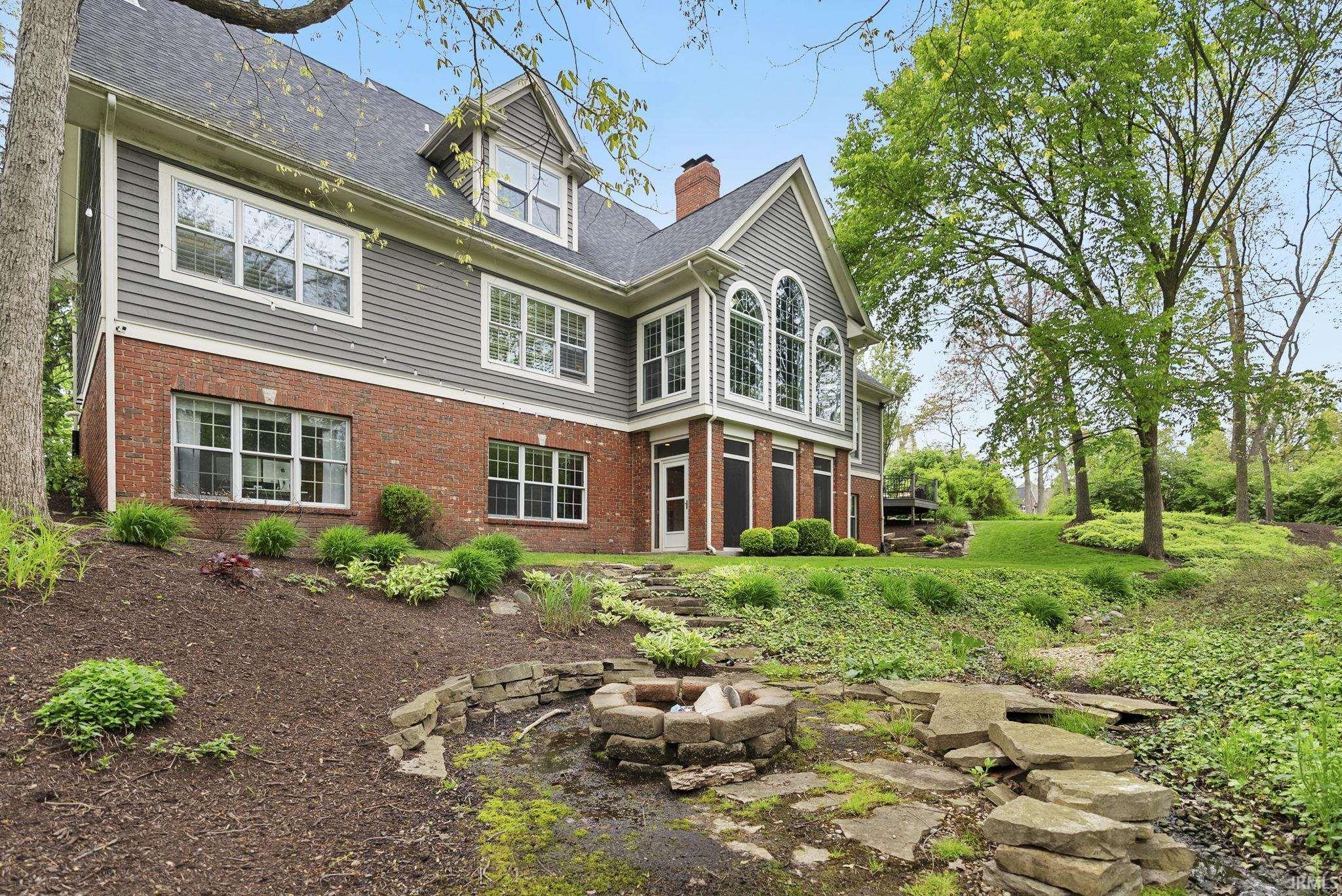 Rear exterior featuring a red brick lower level and gray siding upper level