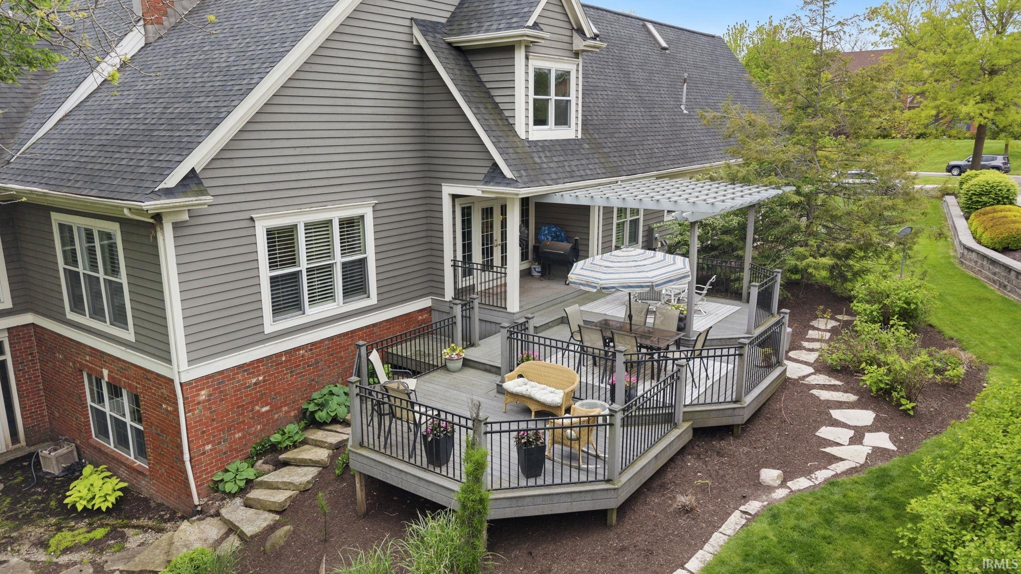 Multi-level composite deck with black metal railings and integrated pergola