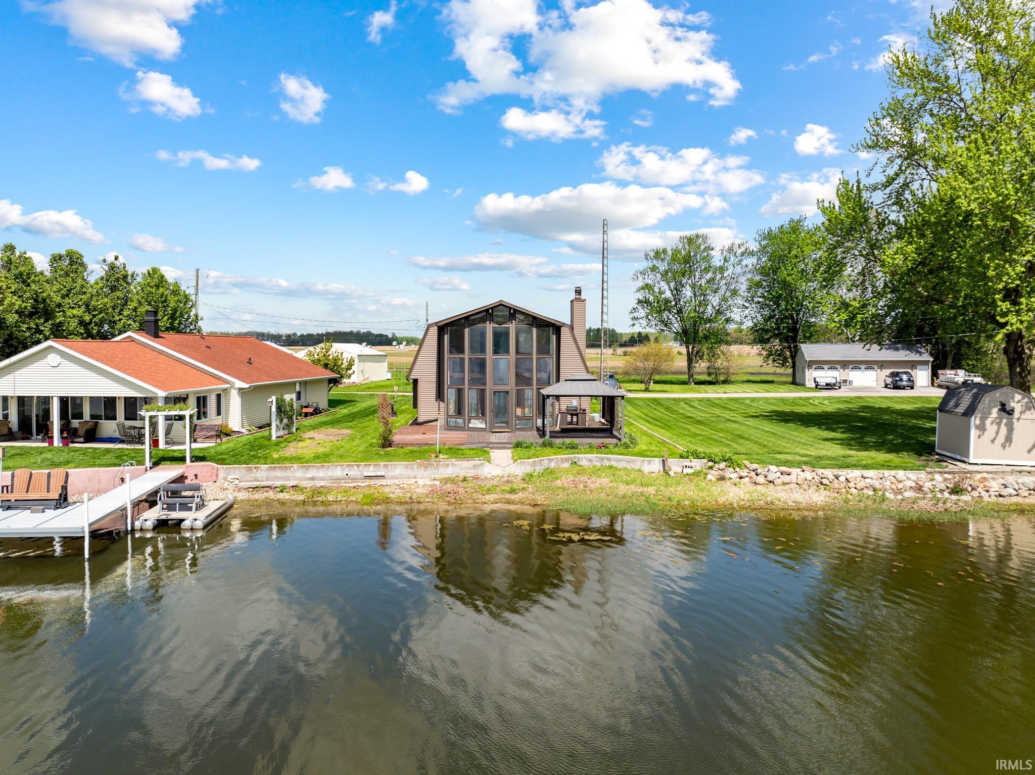 Waterfront property featuring a private dock, two residences, and a detached three-car garage