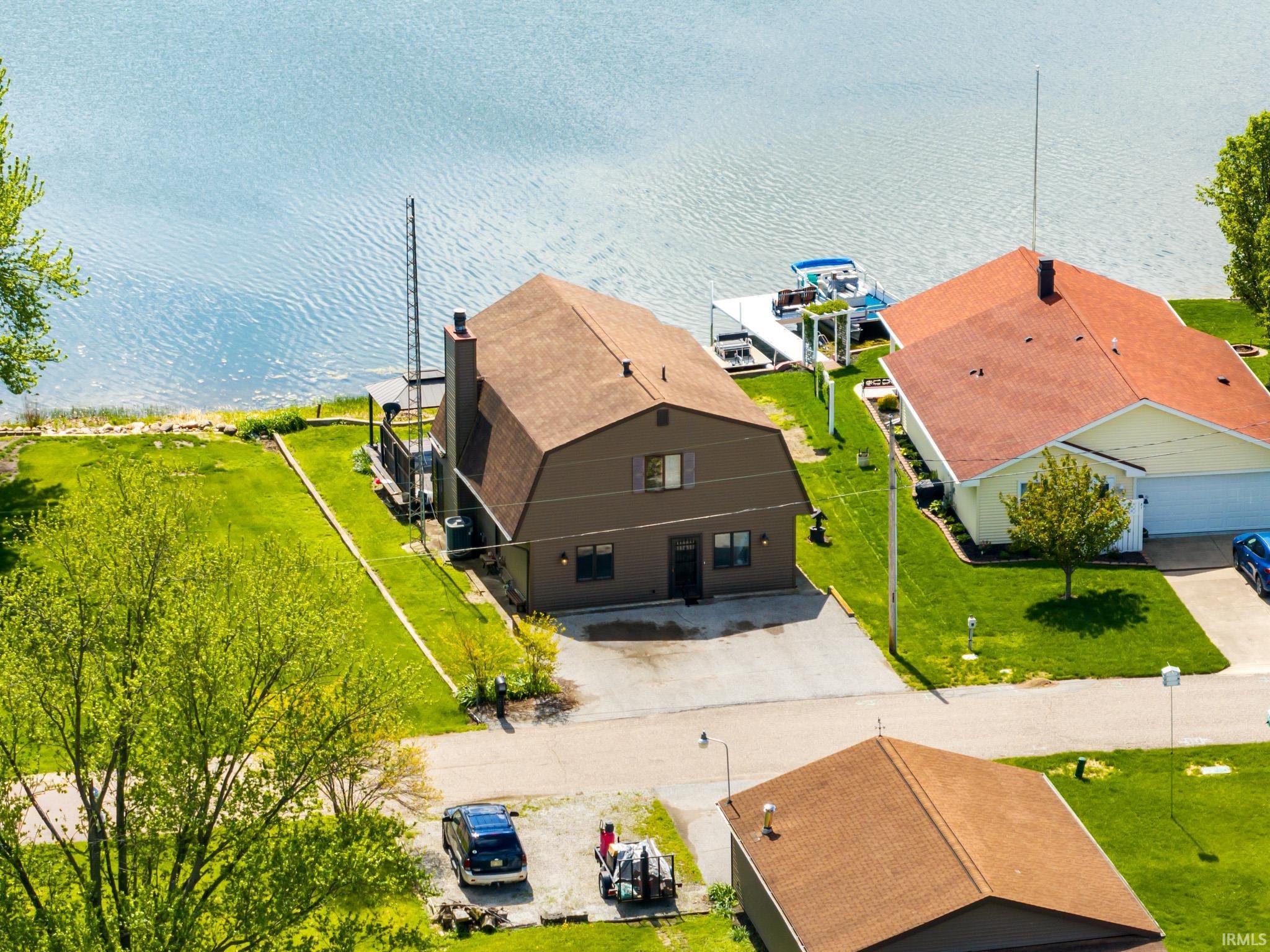Waterfront property featuring a gambrel roof and a private dock with boat lift