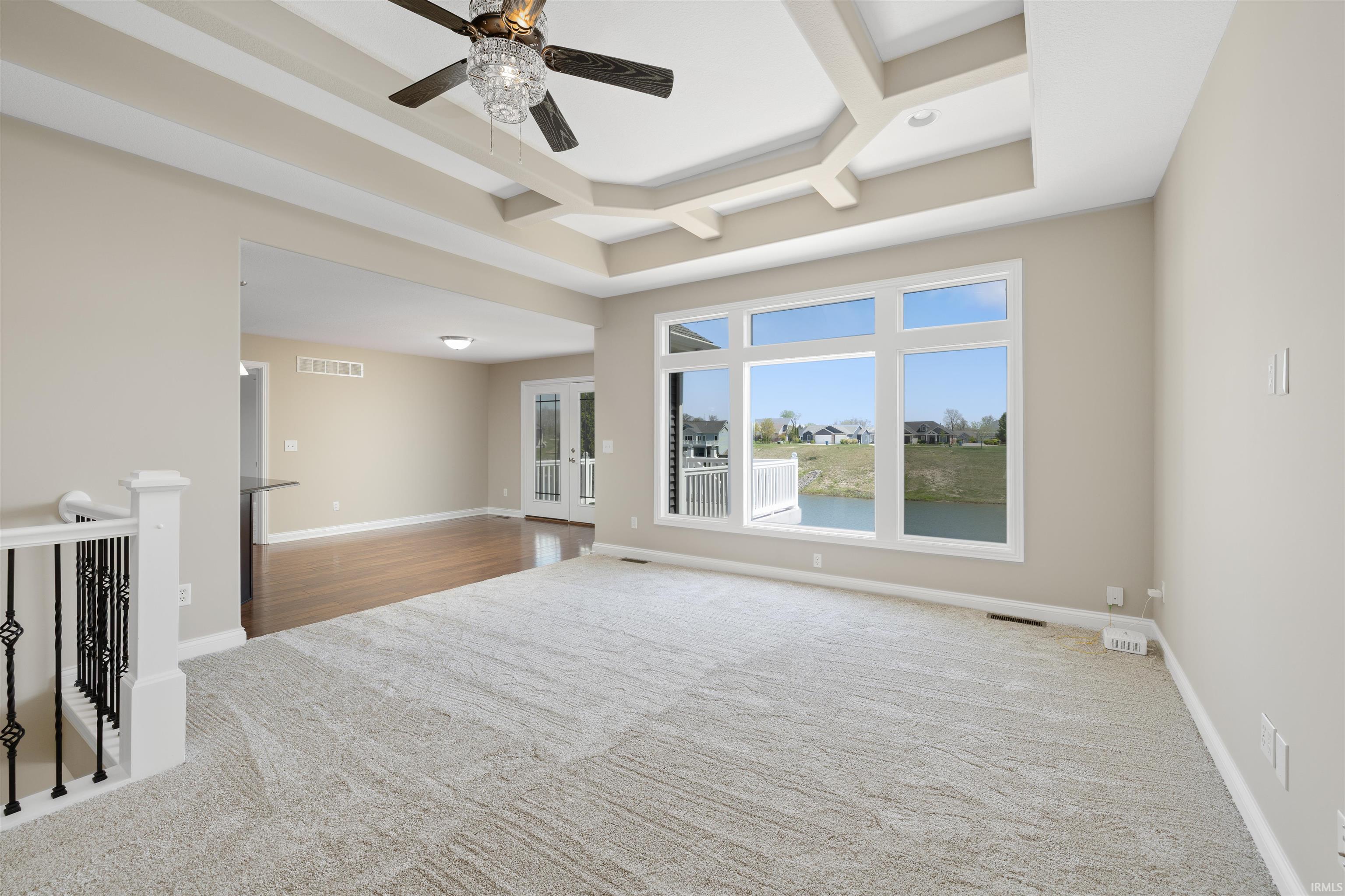 Spacious room with a coffered ceiling and a decorative ceiling fan