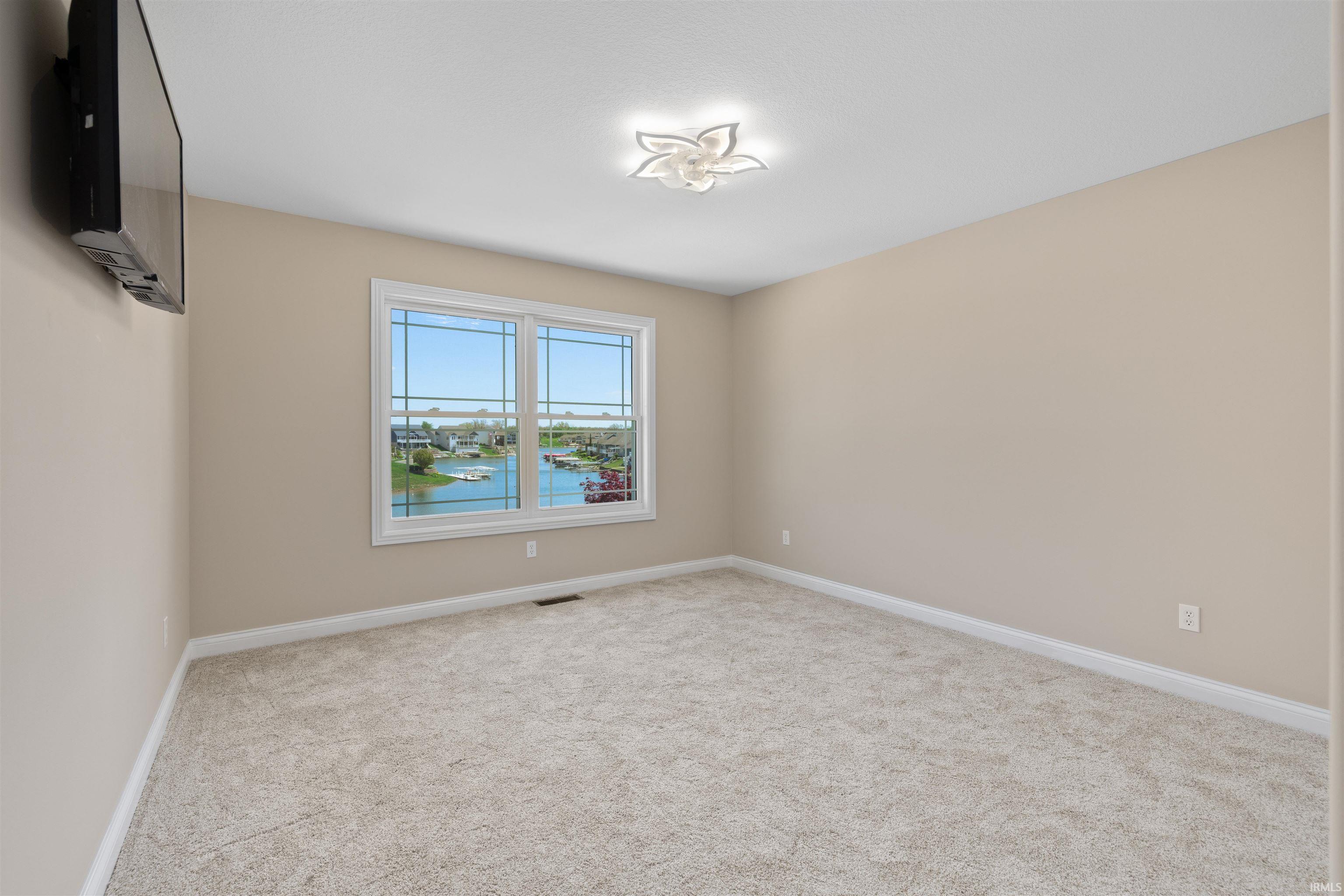 Bedroom featuring neutral wall paint, light-toned carpeting, and white trim