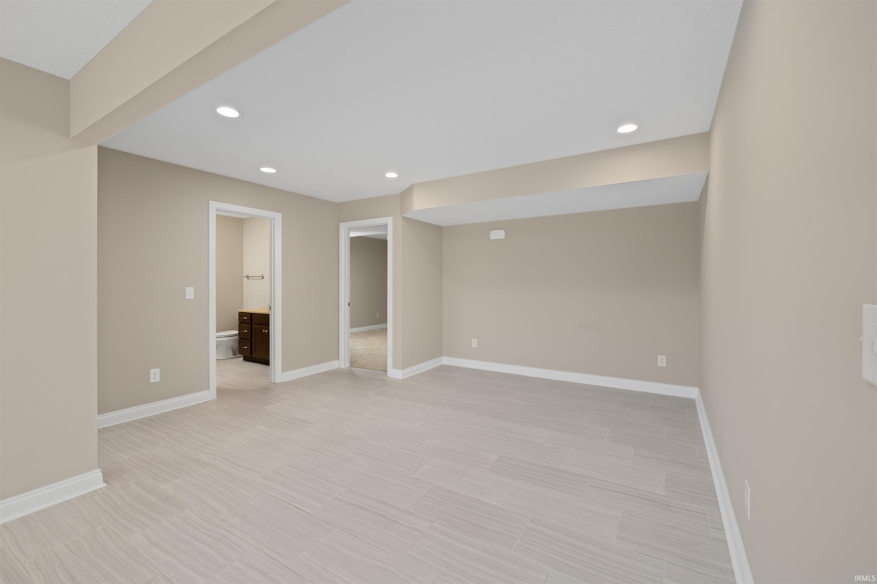 Open-concept room featuring light wood-finish flooring, recessed lighting, and neutral wall tones