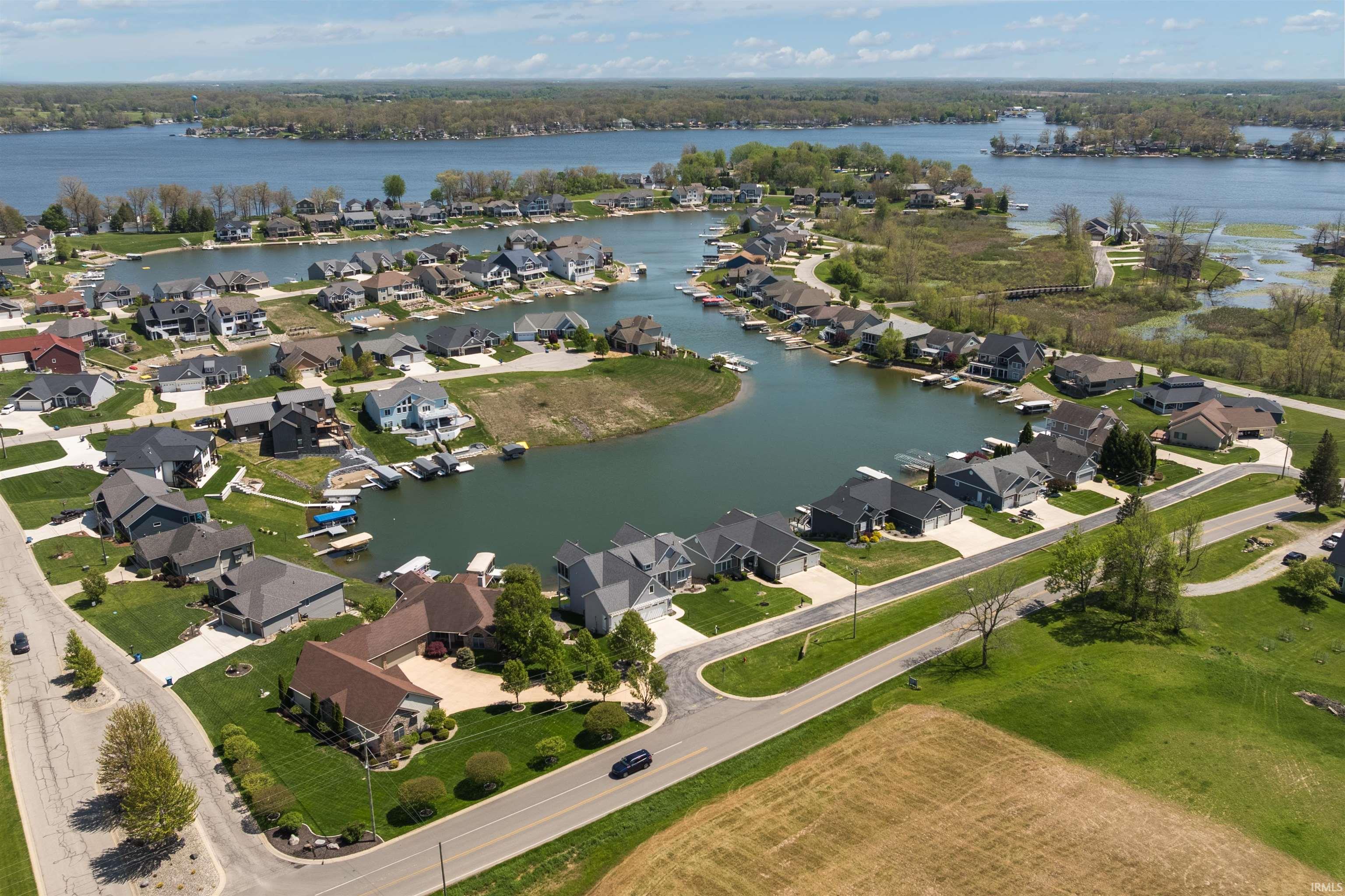 Waterfront residential development featuring multiple single-family homes, private boat docks, paved roadways, and surrounding natural waterways