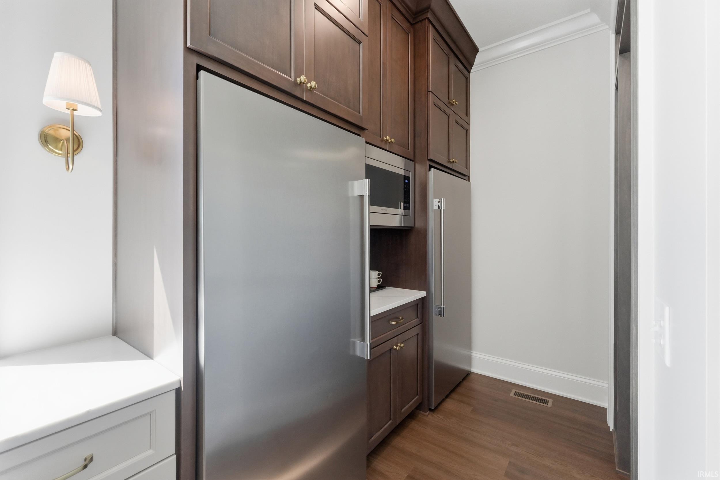 Integrated stainless steel appliances, including a microwave and two refrigerators
