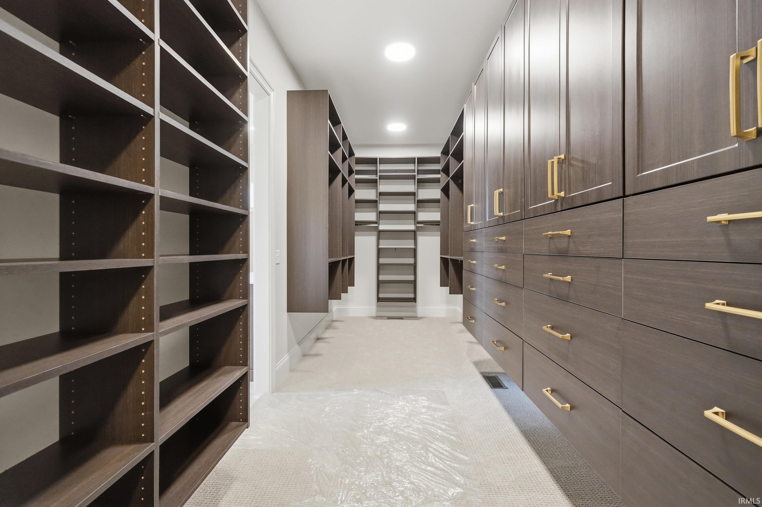 Expansive dressing room featuring dark wood-finish cabinetry and shelving
