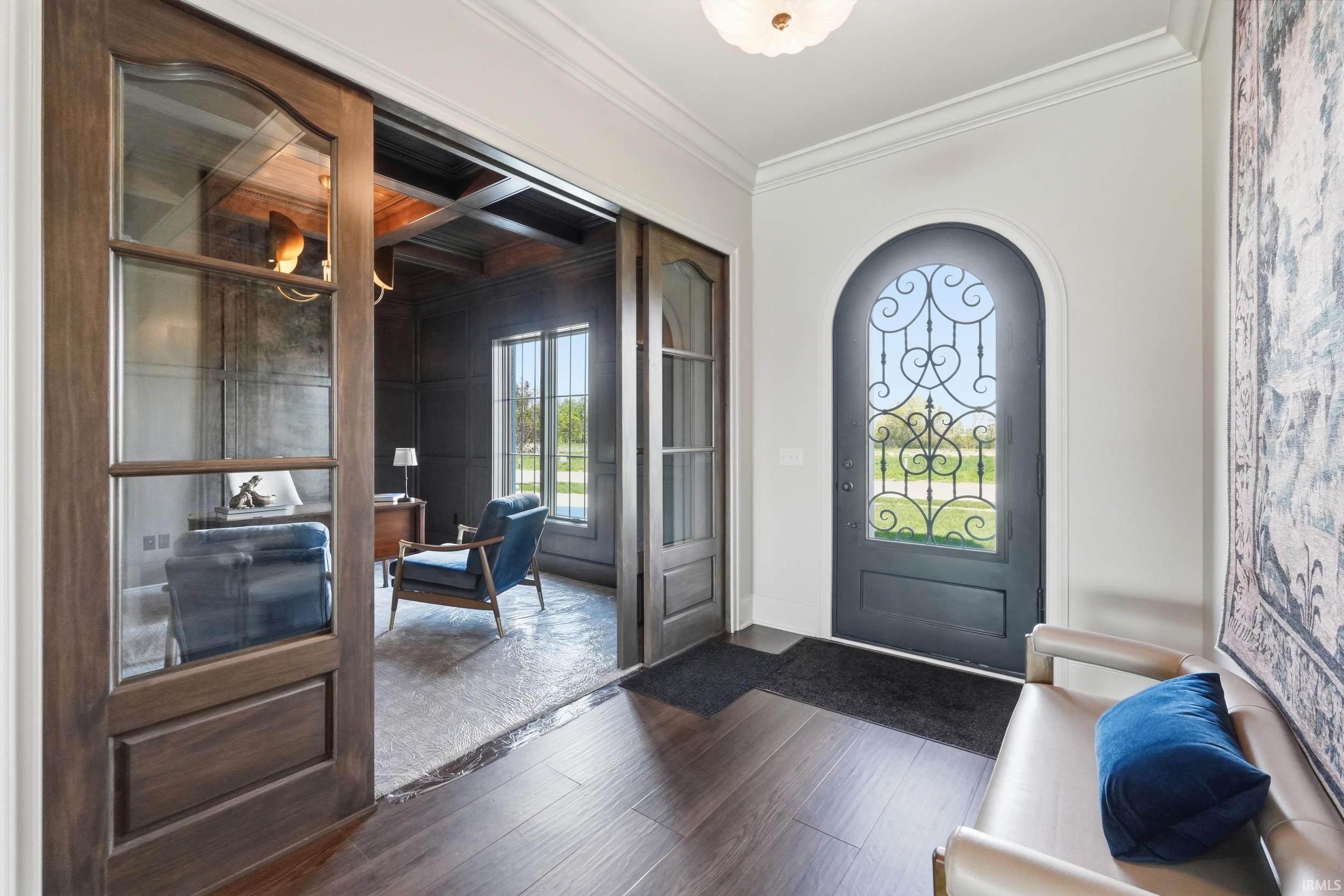 Arched front door with decorative wrought iron detailing and clear glass paneling