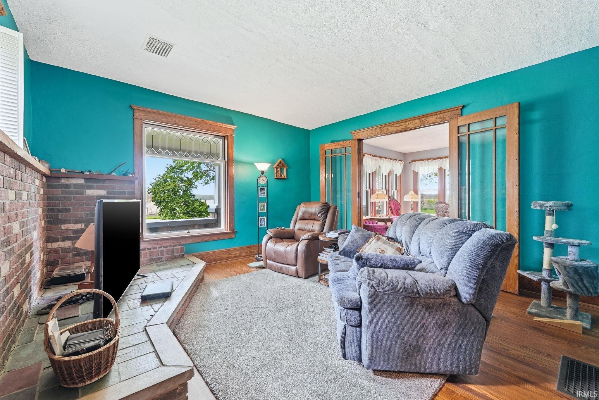 Living area featuring a brick hearth and a window with wood trim