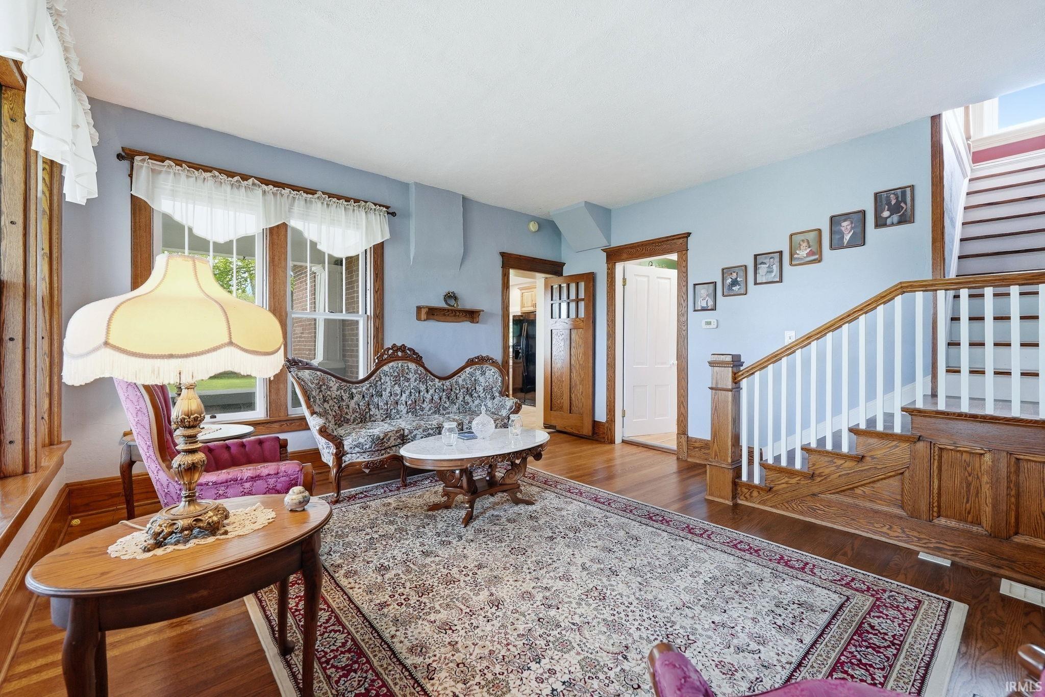 Hardwood flooring throughout, featuring a natural wood staircase with white balusters