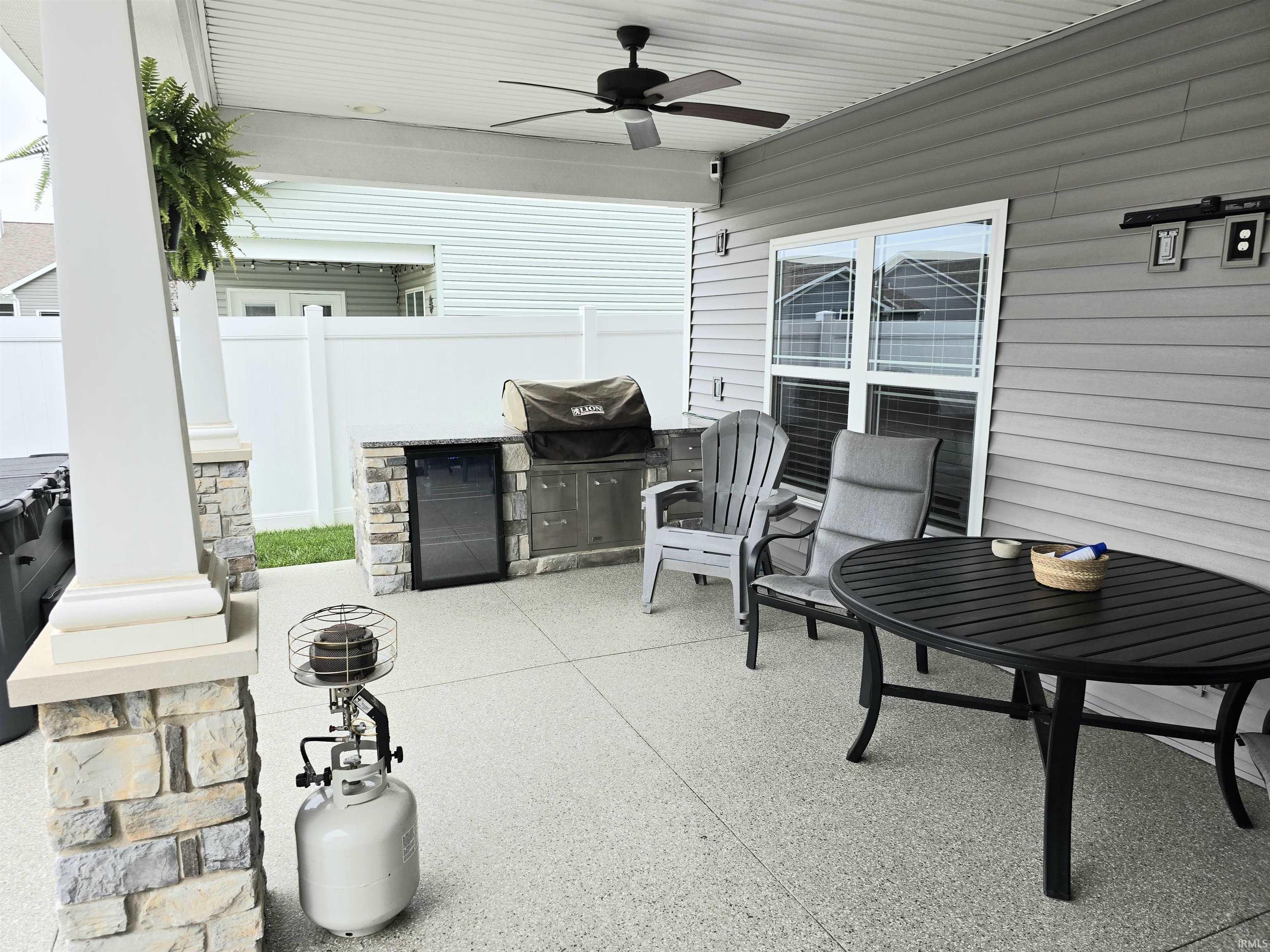 Covered patio featuring an outdoor kitchen with integrated refrigerator