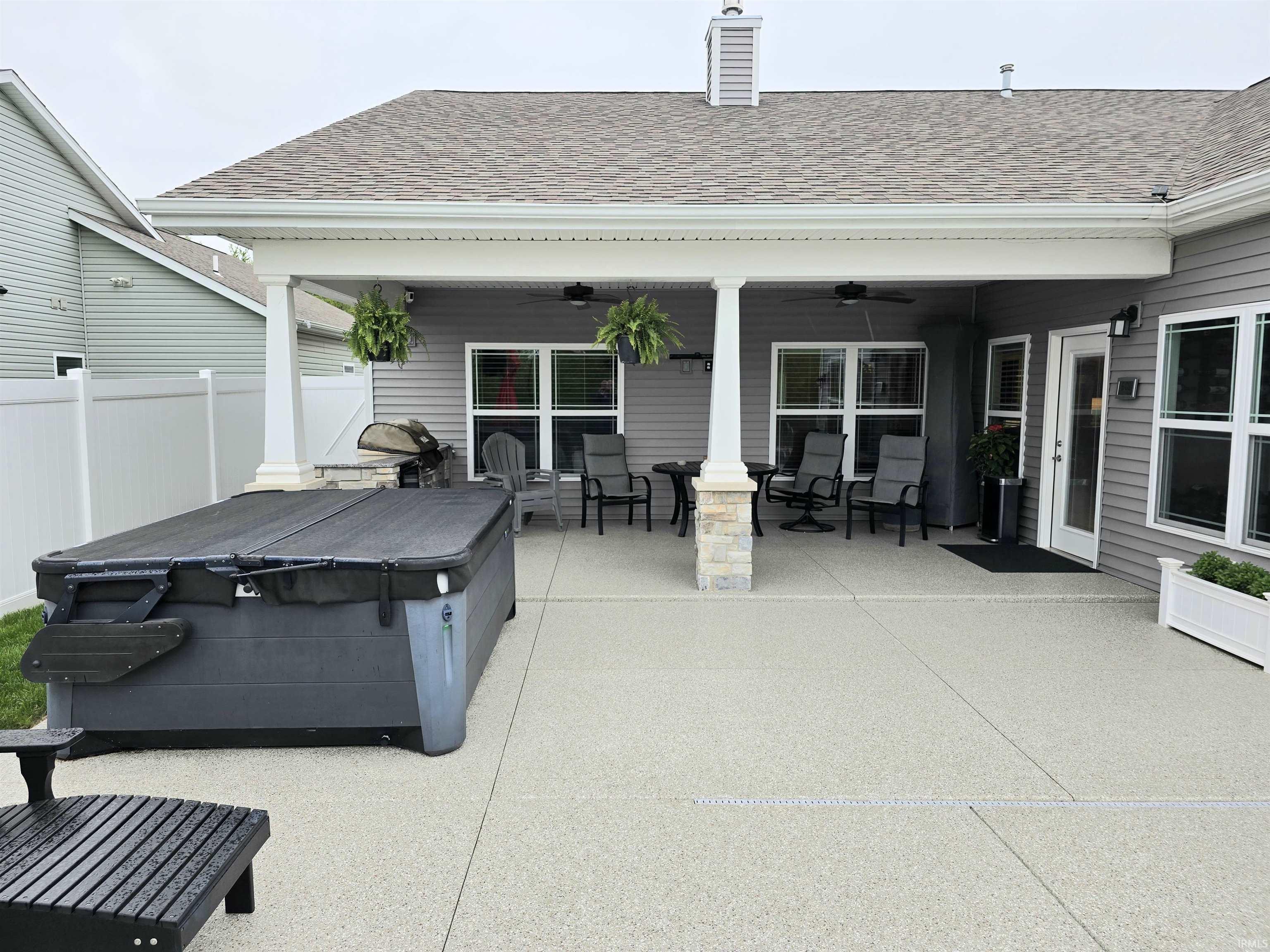 Spacious outdoor patio featuring a covered area with recessed lighting and ceiling fans