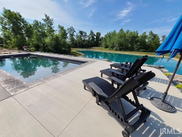 Rectangular swimming pool with concrete decking and natural stone coping