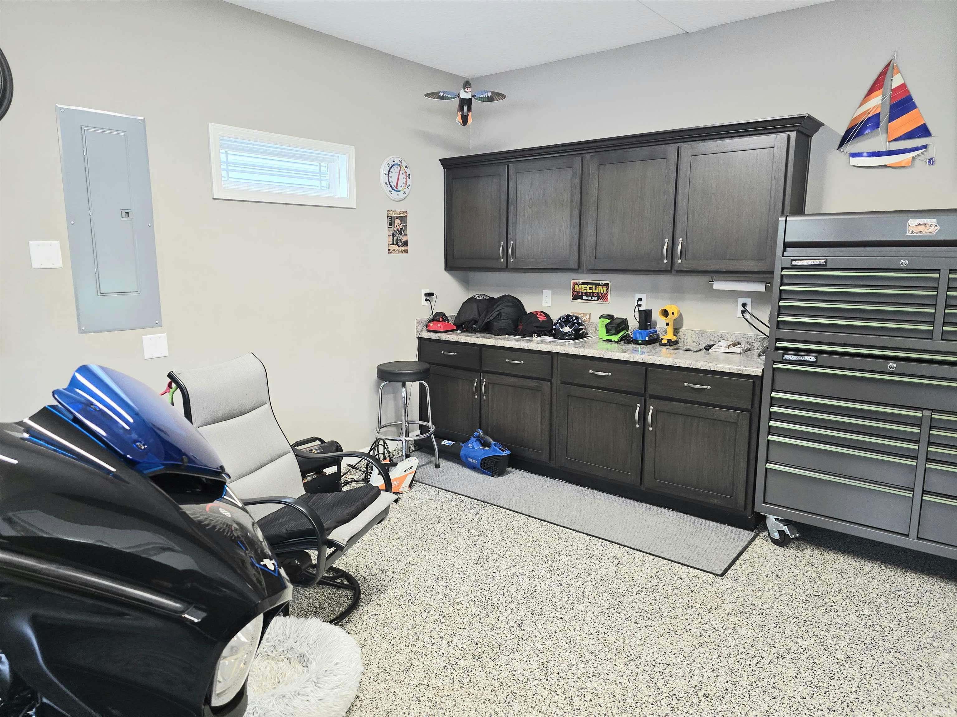 Garage space featuring speckled epoxy flooring and storage cabinets.