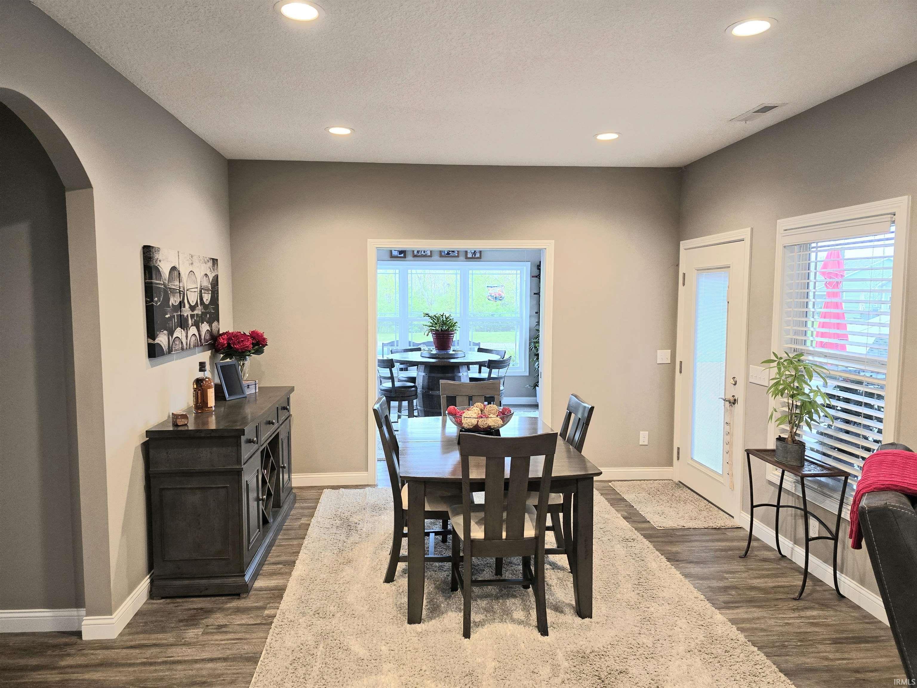 Spacious dining area featuring recessed lighting, durable LVP flooring, and great views toward the pool & pond.