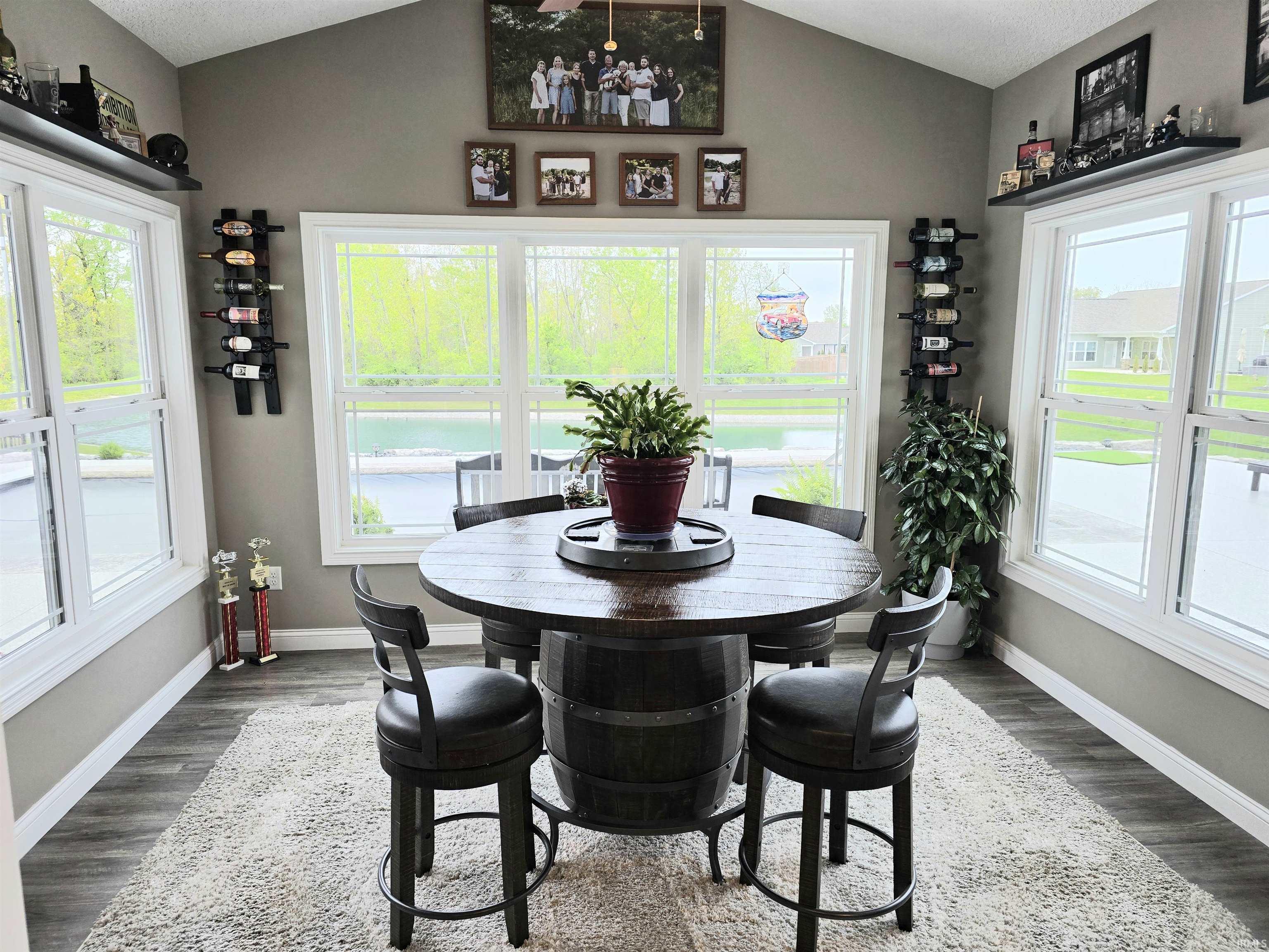 Sunroom featuring abundant natural light, vaulted ceiling, LVP flooring, and multiple window exposures