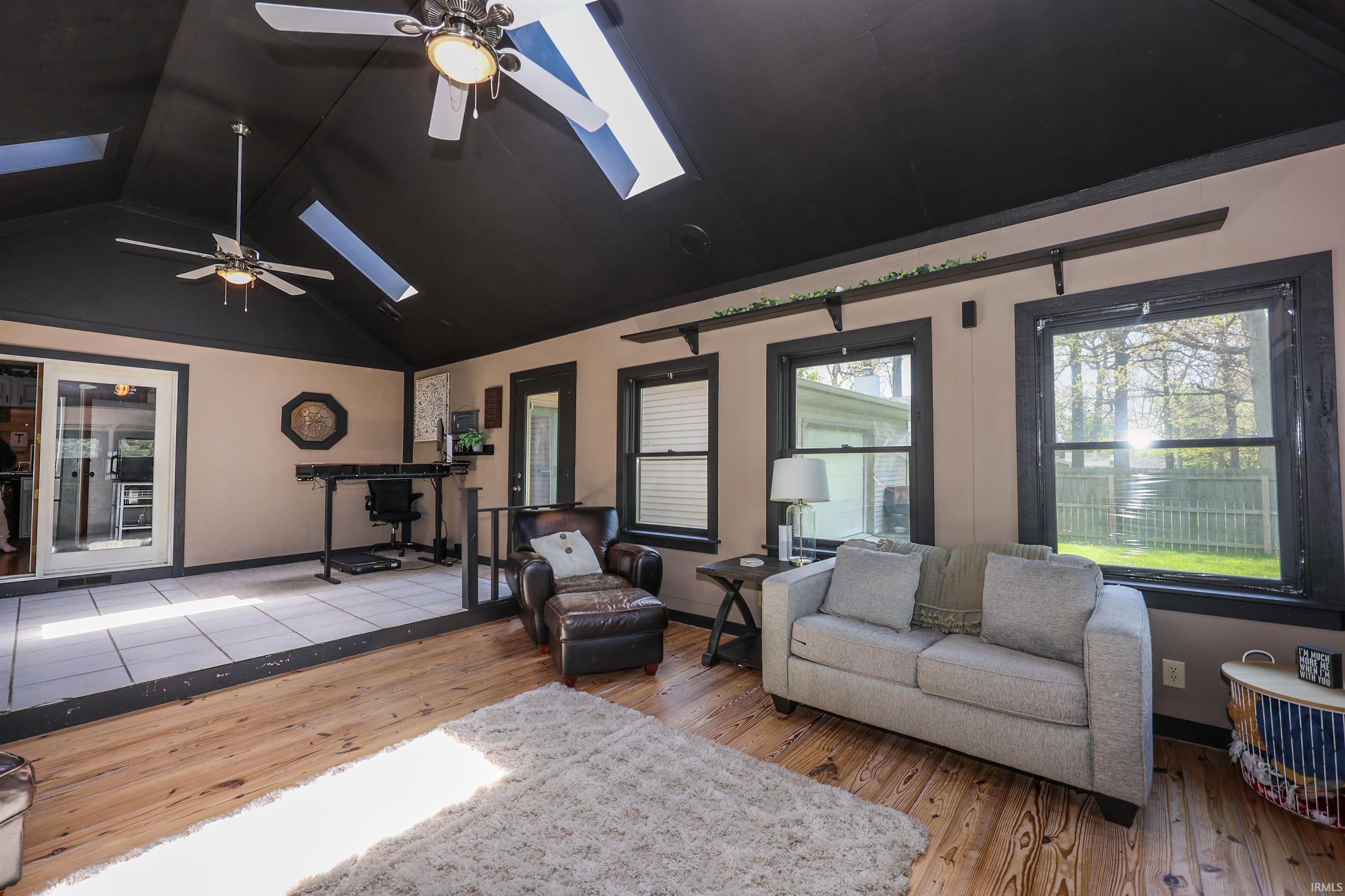 Vaulted ceiling featuring skylights and ceiling fans