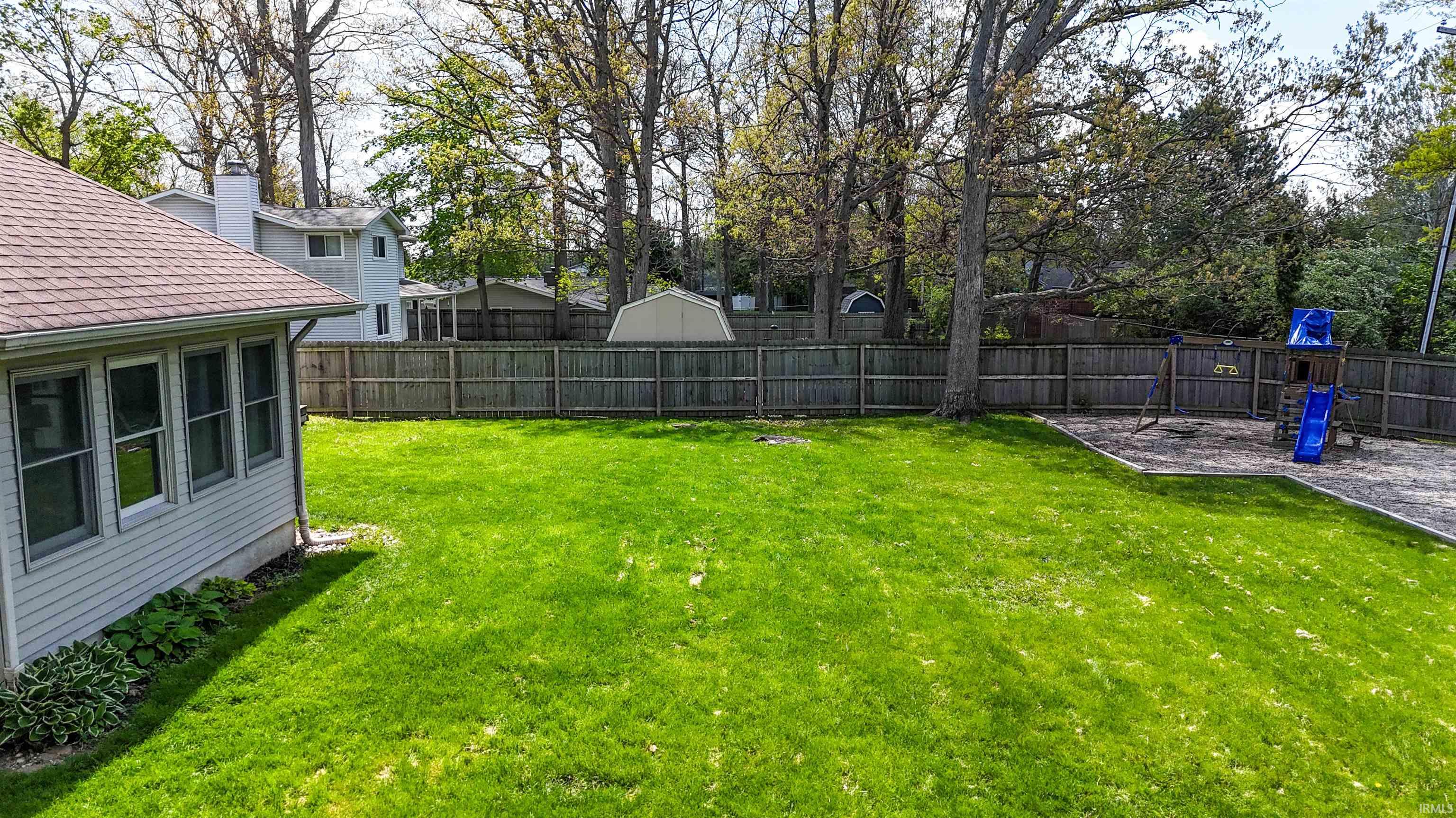 Expansive green lawn with a full privacy fence
