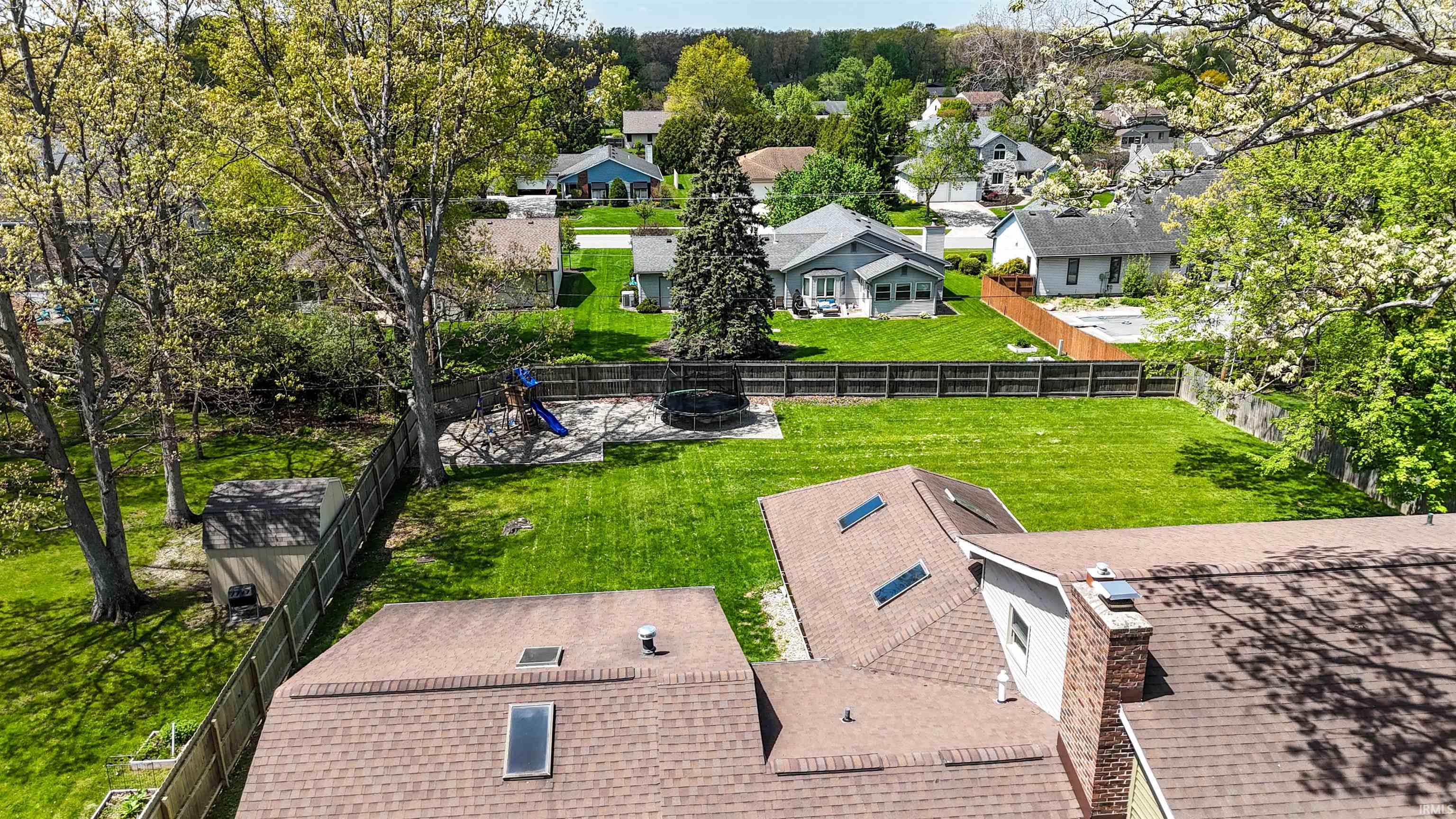 Expansive green lawn surrounded by mature trees