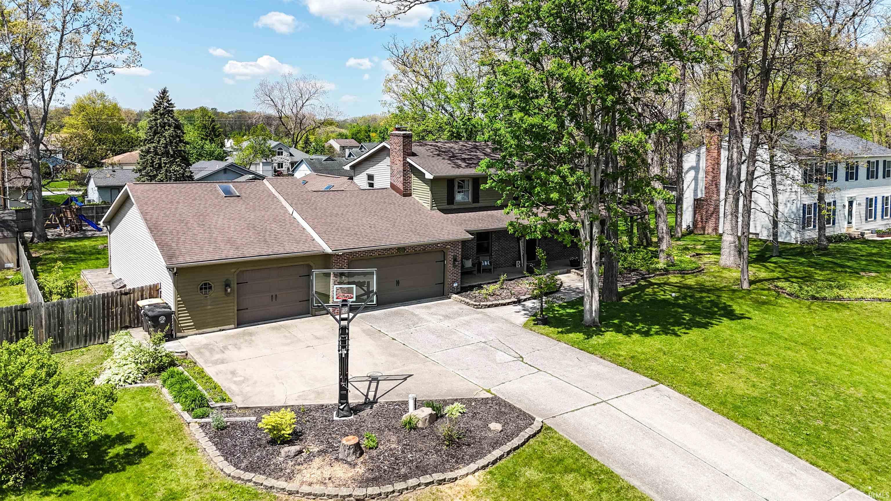 Expansive driveway leading to a two-car garage with arched window accents