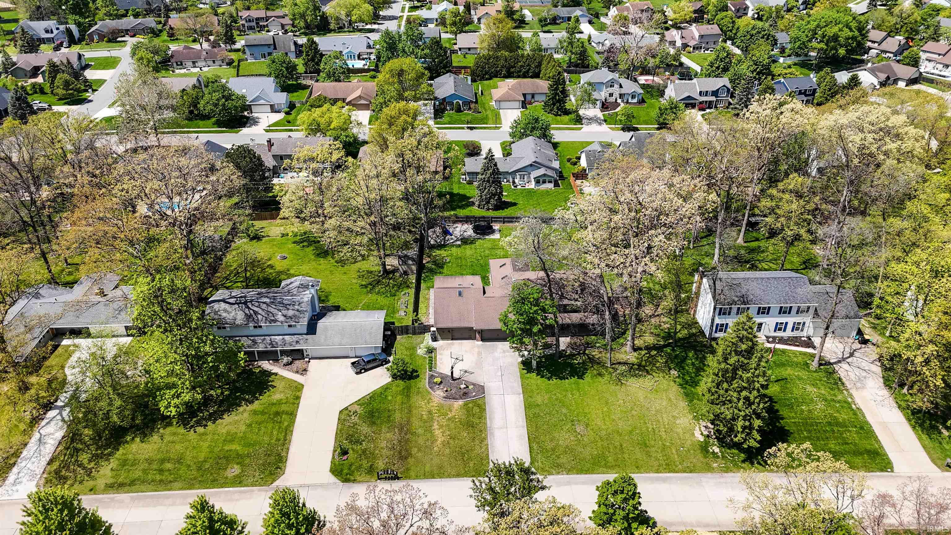 Aerial perspective showcasing a residential neighborhood with established homes and mature trees