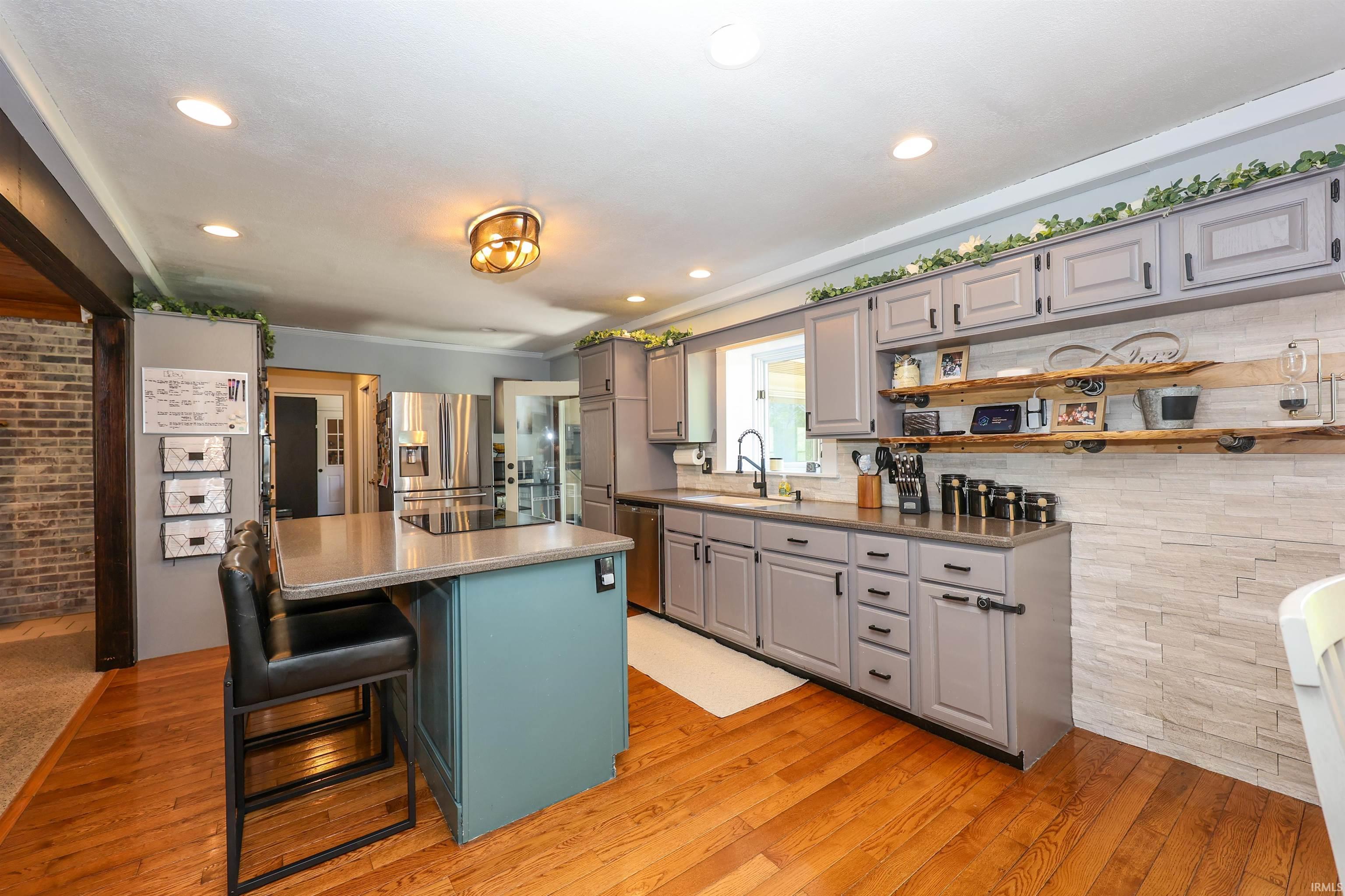 Kitchen featuring wood-finish flooring, recessed lighting, and a center island with a built-in cooktop