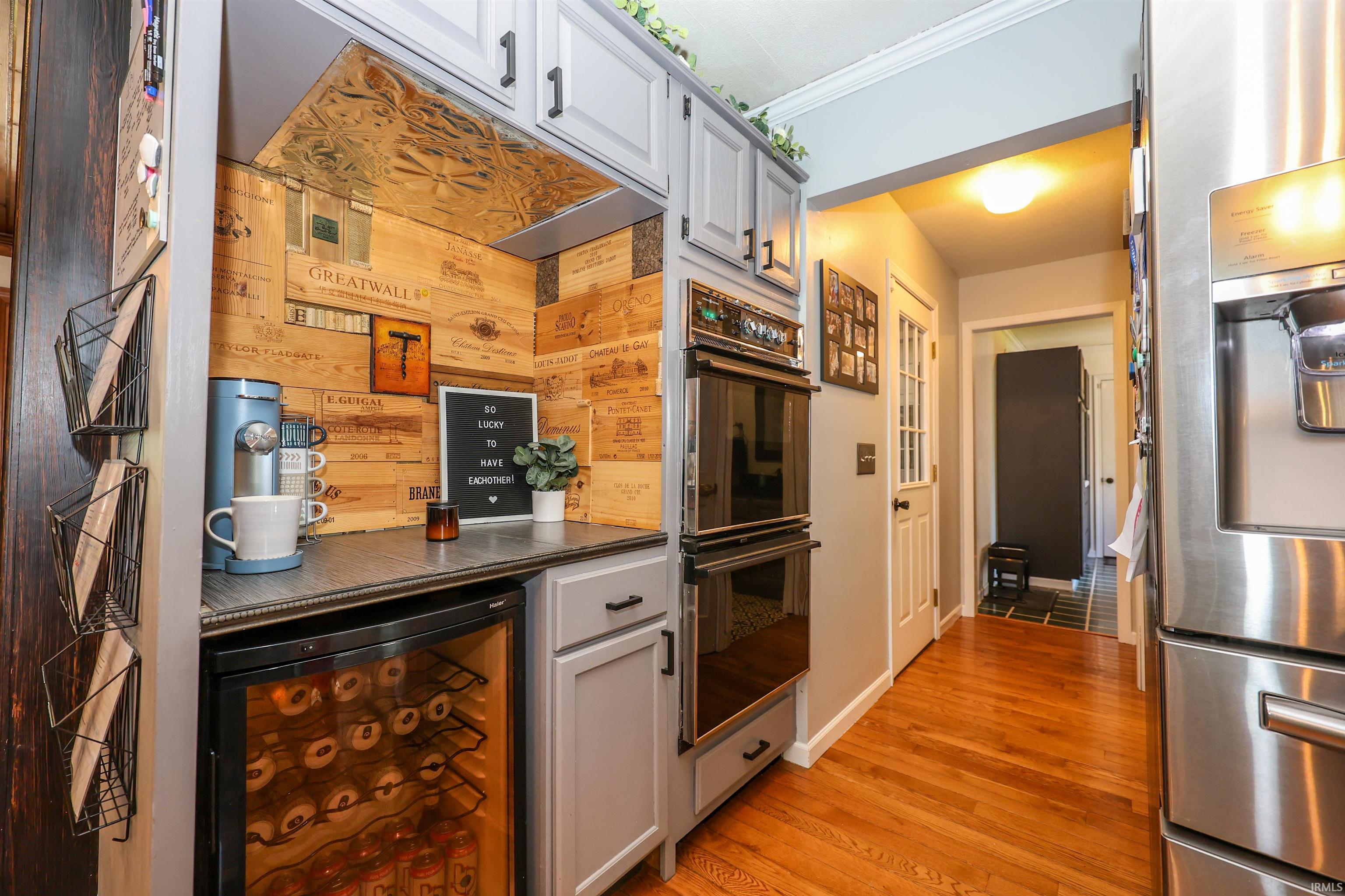 Dedicated beverage station featuring custom wood paneling and a built-in wine refrigerator