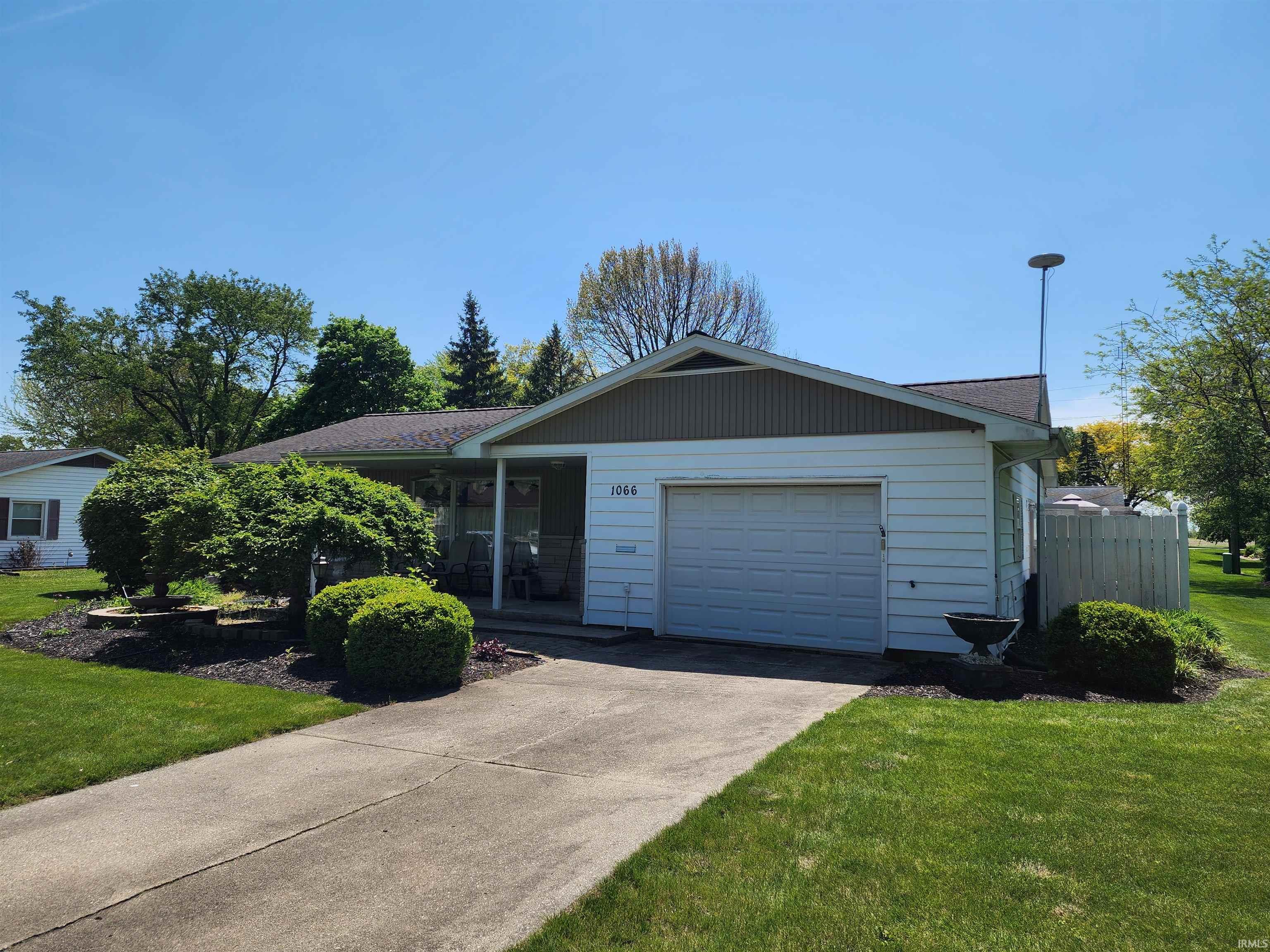 Ranch-style residence featuring white siding and an attached garage with a white door