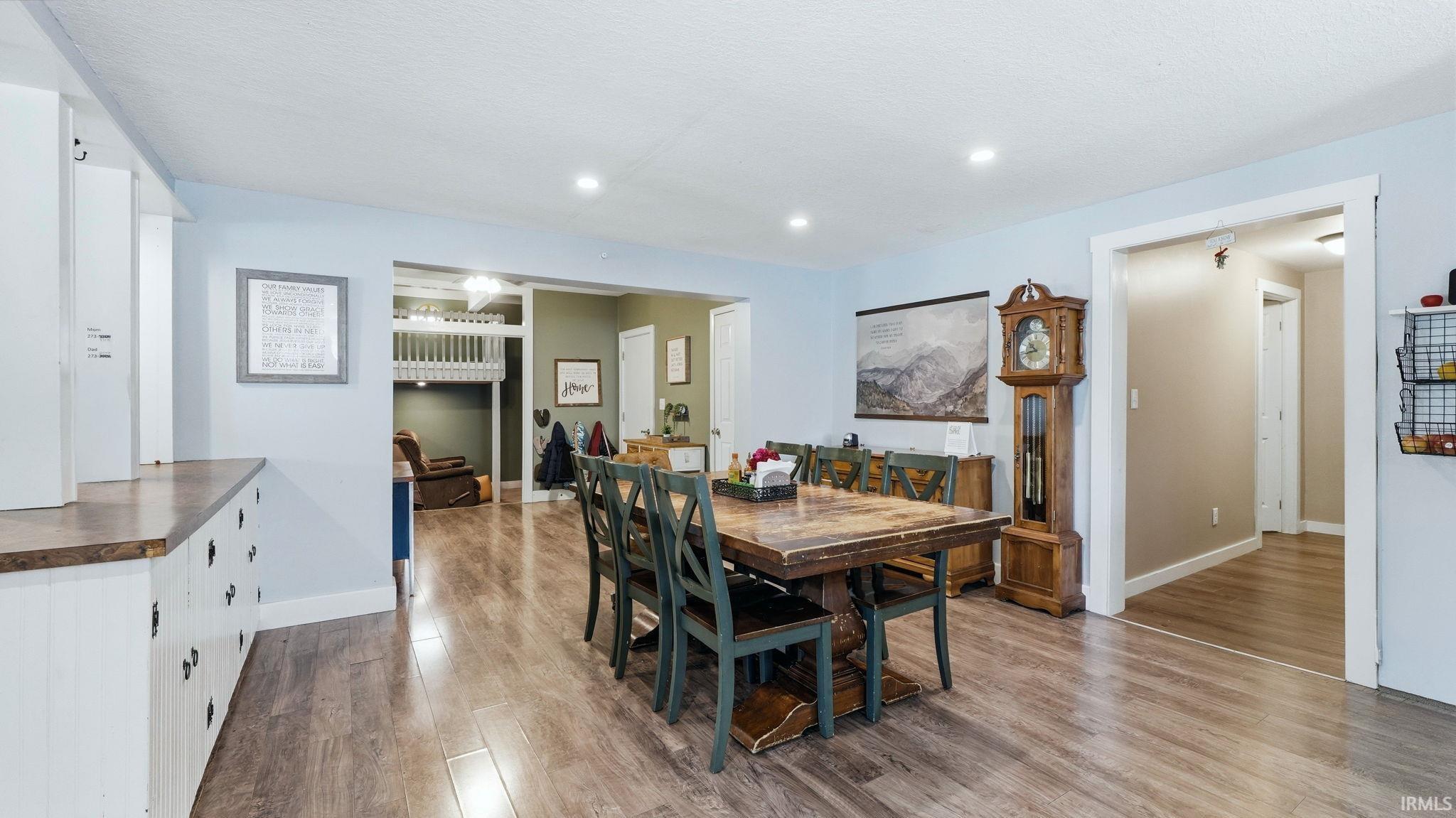 Dining area featuring wood-finish flooring, recessed lighting, and light blue wall tones