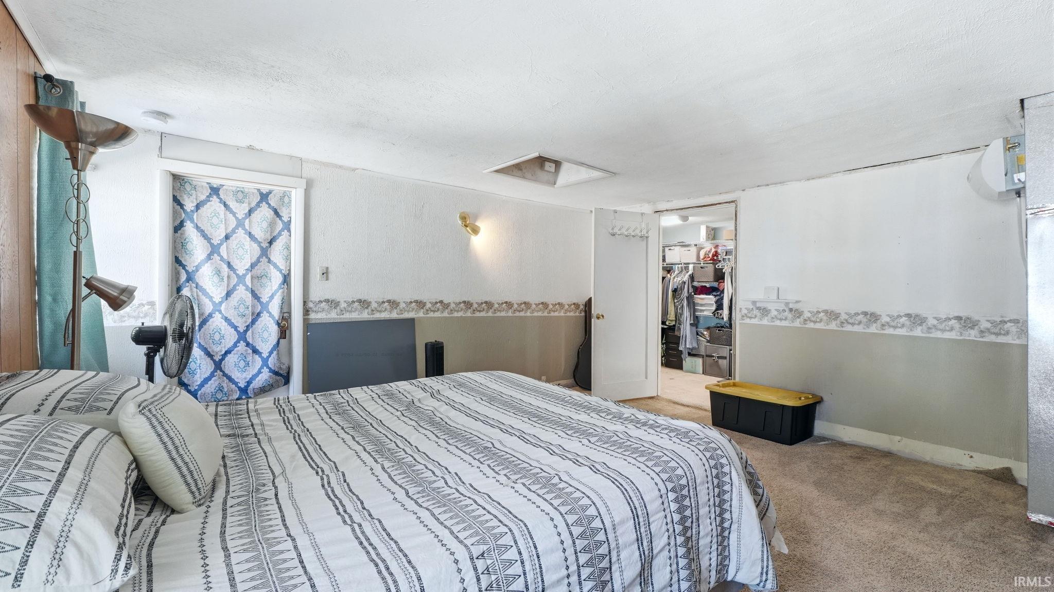 Carpeted room featuring light-colored walls with a decorative border and a lower painted section