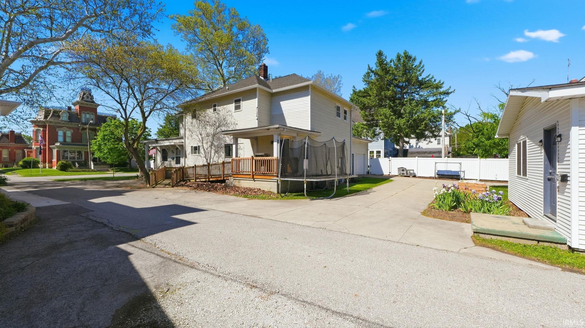 Paved driveway leading to a detached structure and a multi-level deck