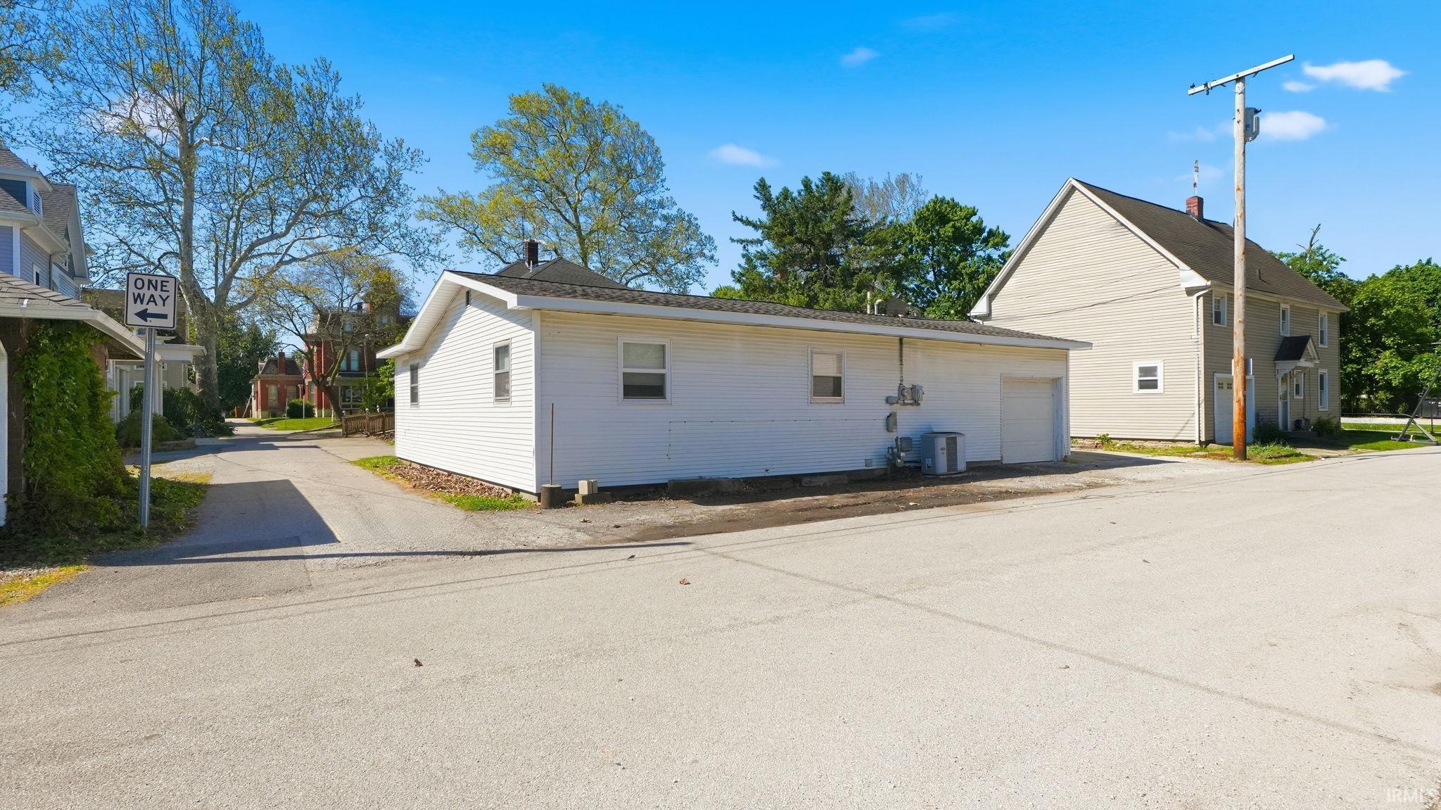 White siding structure featuring an attached garage with a white door