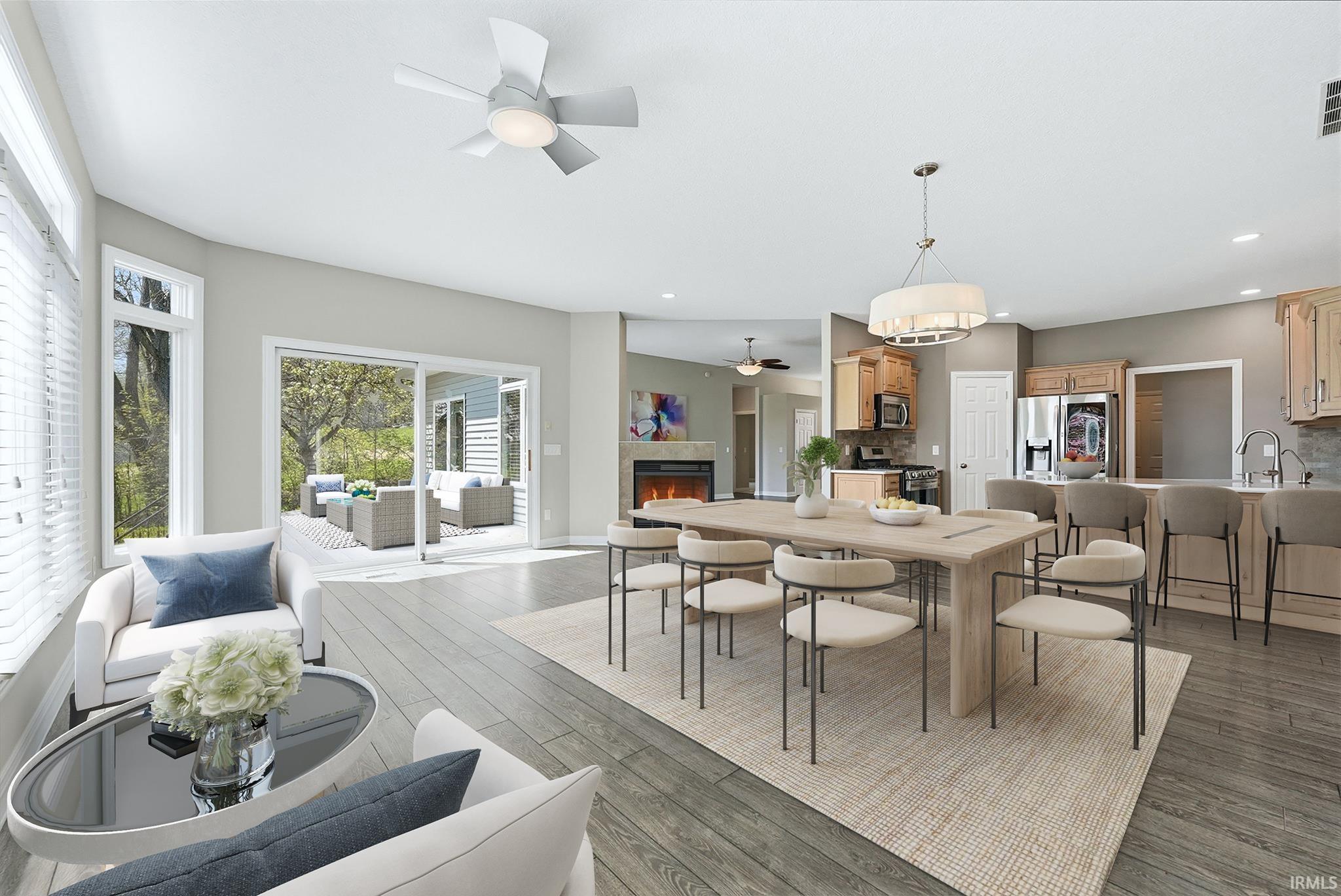 Spacious living area featuring wood-finish flooring, a contemporary ceiling fan, and large windows