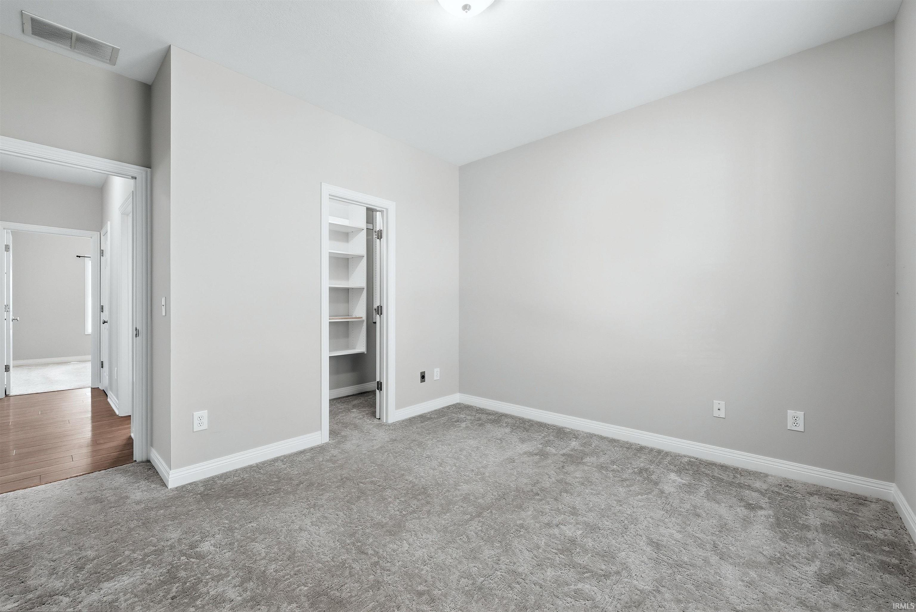 Carpeted room with light gray walls, white trim, and a ceiling-mounted light fixture