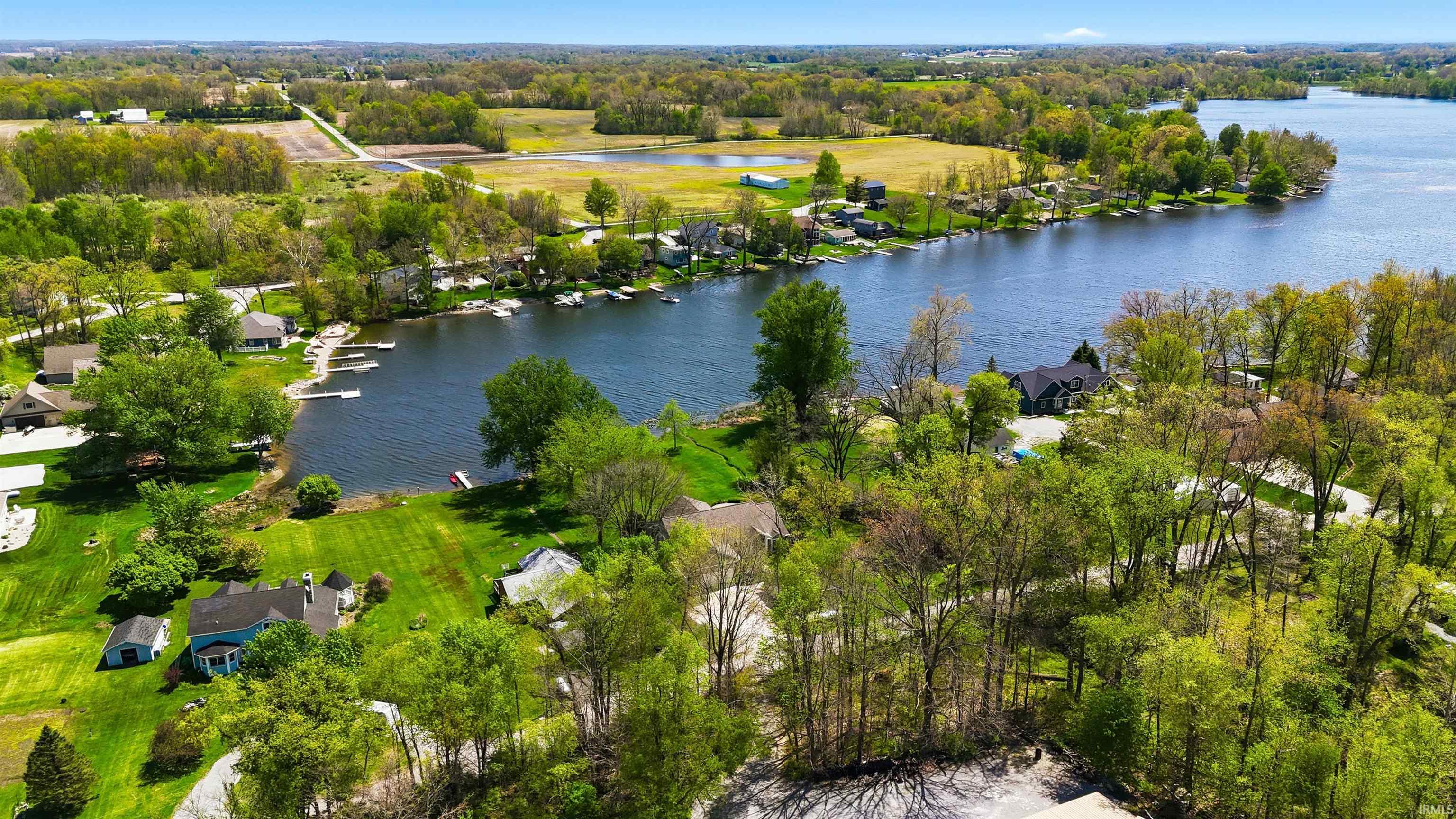 Expansive water frontage featuring multiple private docks and lush green lawns