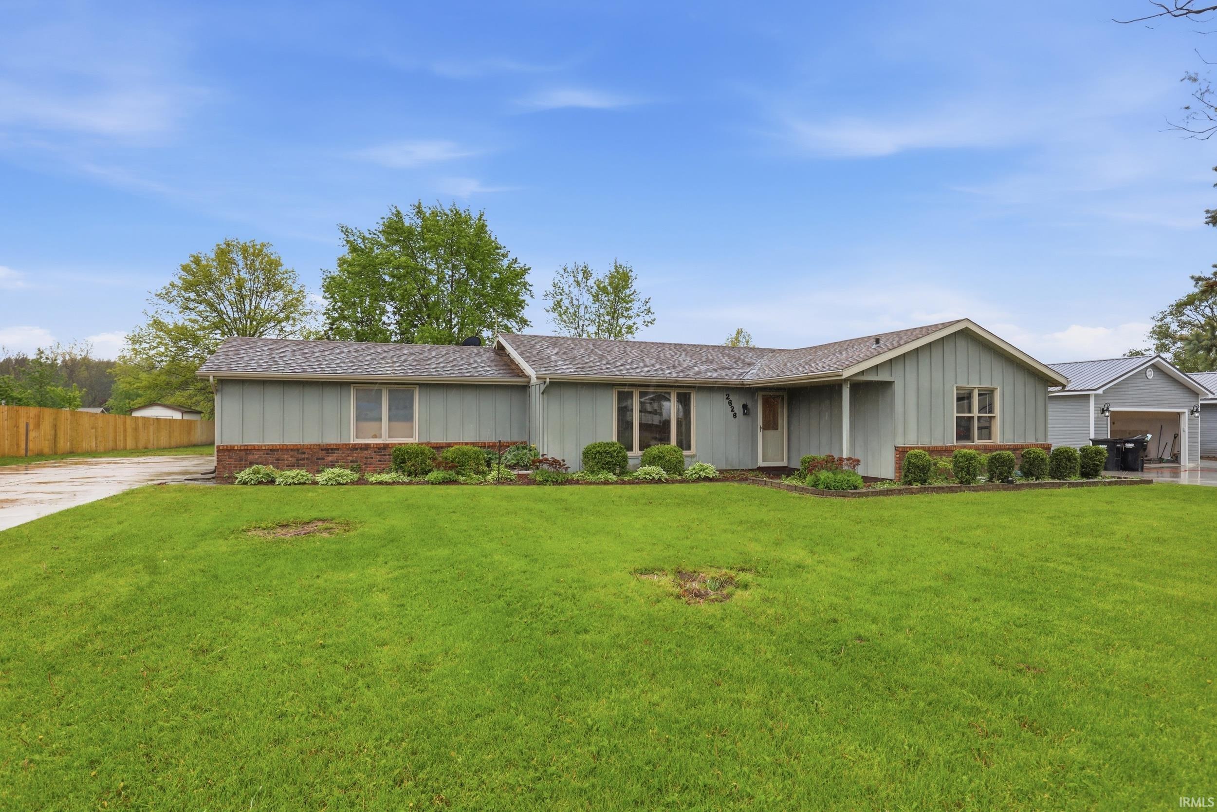 Ranch-style residence featuring siding, a brick foundation, and a shingle roof