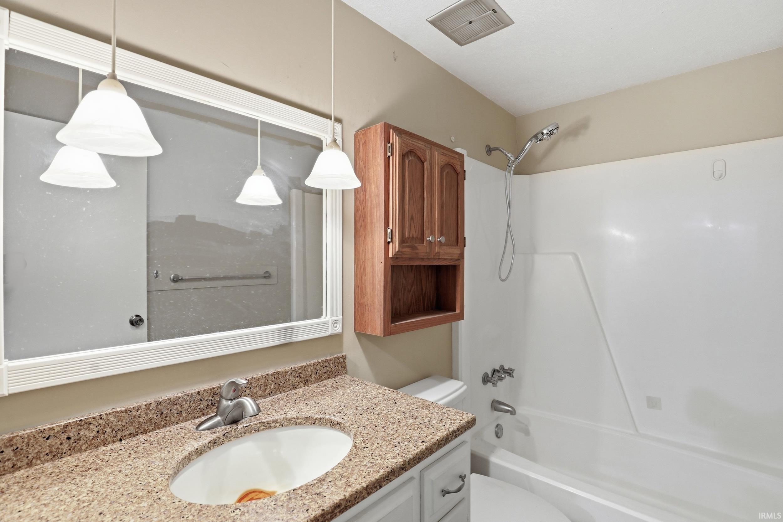 Bathroom vanity with a speckled countertop and an undermount sink